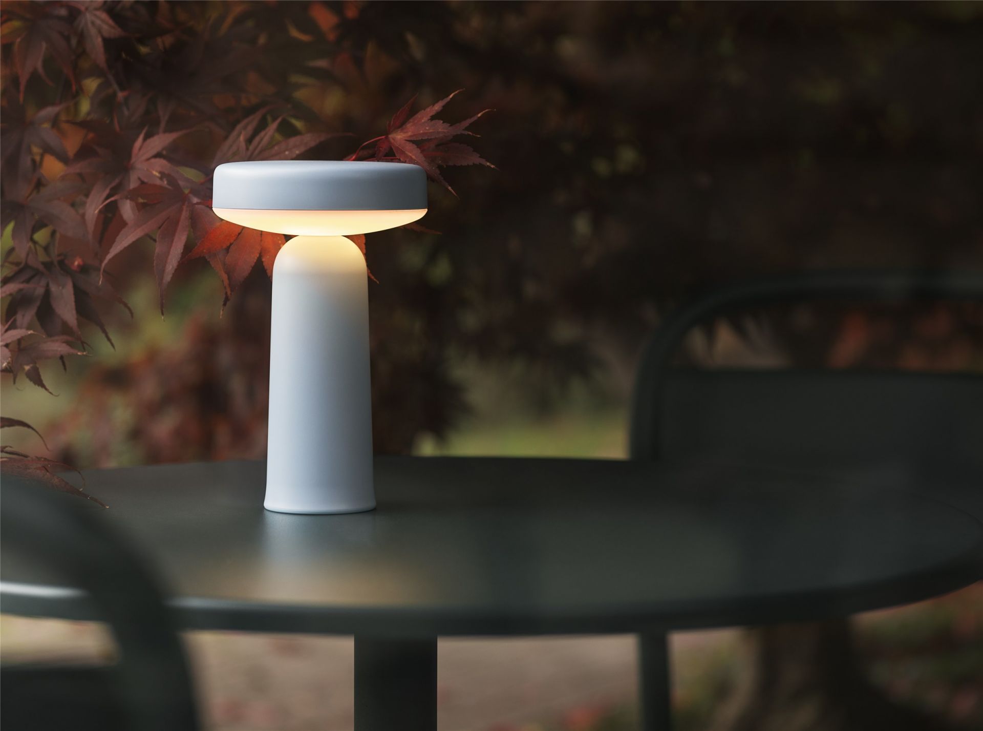 Ease Portable Lampe in Hellblau auf Tisch, Akku Tischleuchte für drinnen und draußen.