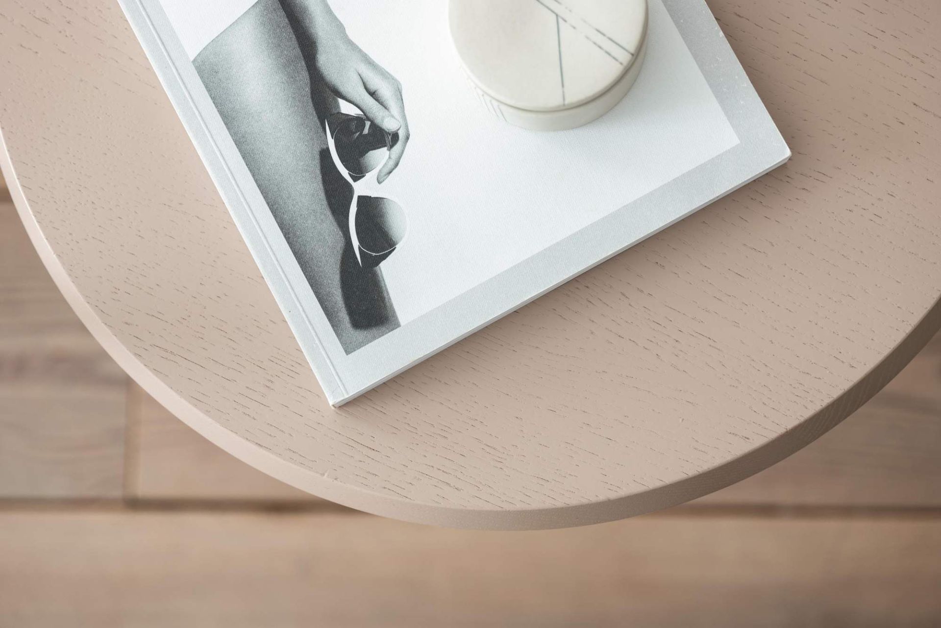 Nahaufnahme des Schönbuch Amanita Beistelltisches (Ø 46 cm) in sanftem Rosa mit Dekoration.