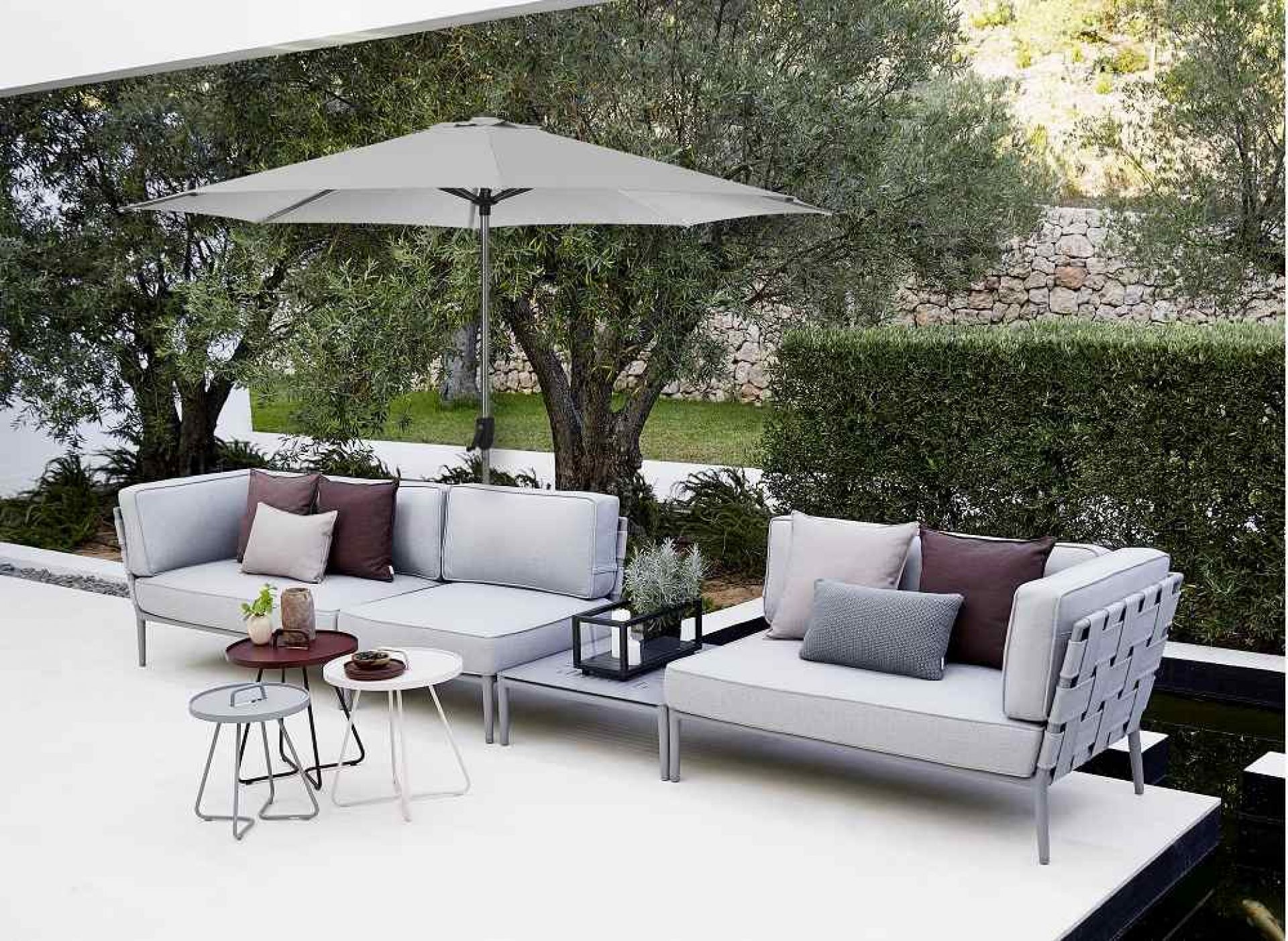 Sunshade Parasol Sonnenschirm von Cane-Line über Lounge-Möbeln auf einer Terrasse, für Schatten und Entspannung.