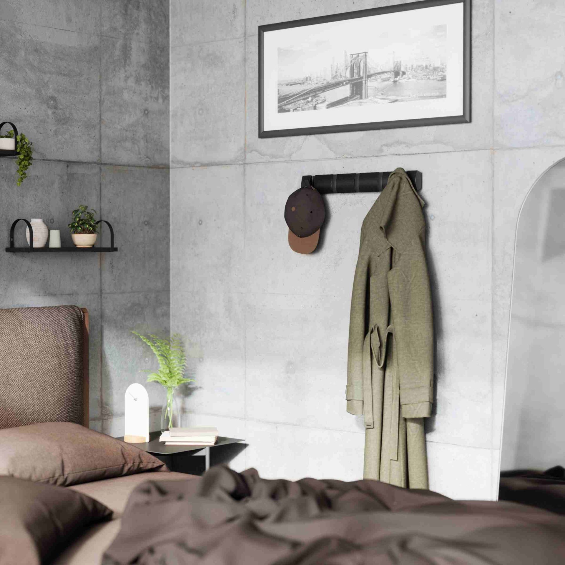 Umbra Flip Hook Wandgarderobe mit fünf Haken in Schwarz, an der eine Jacke und eine Mütze hängen.