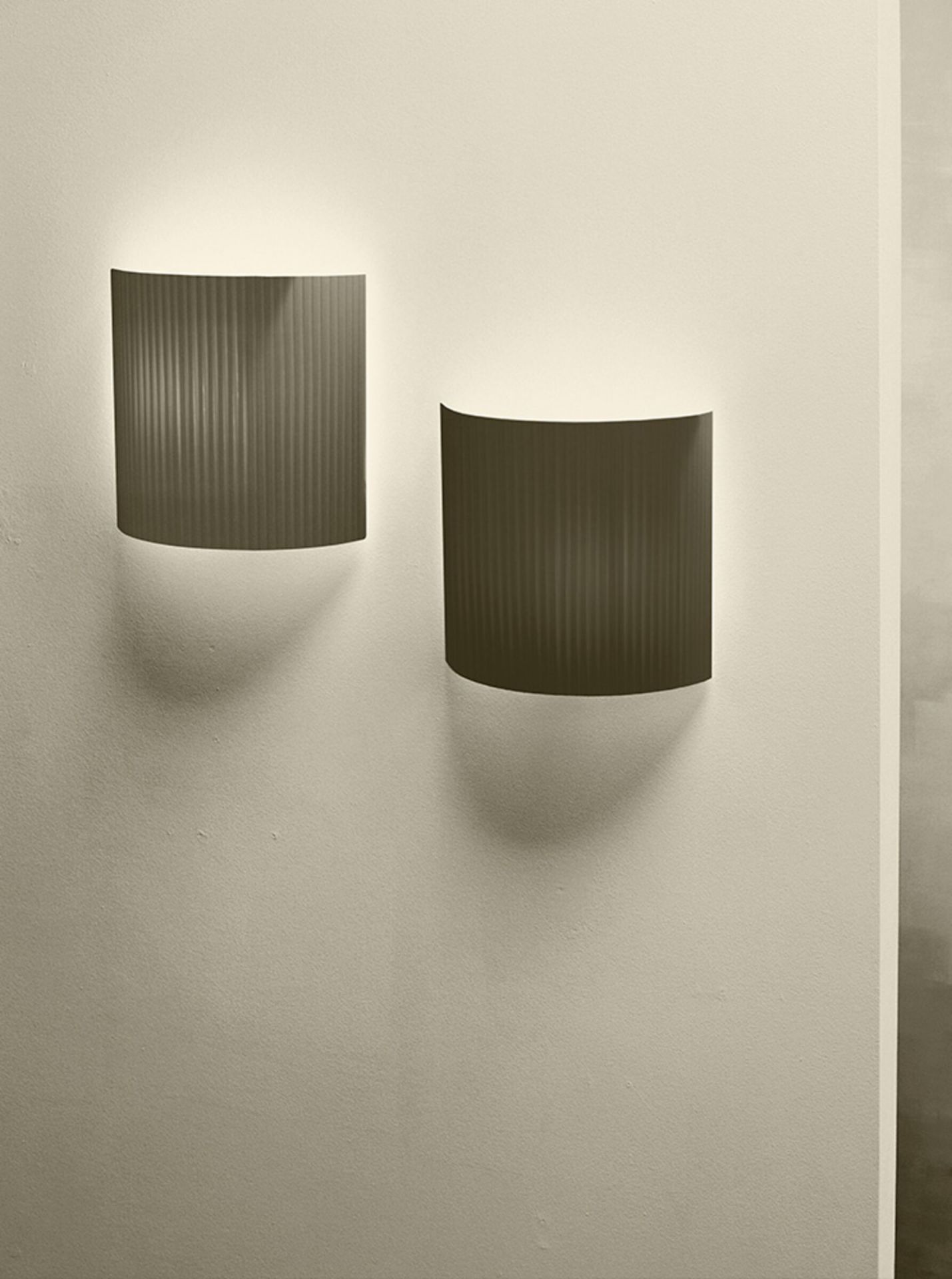 Zwei quadratische Comodín Wandleuchten in Terrakotta-Optik von Santa & Cole an einer Wand.