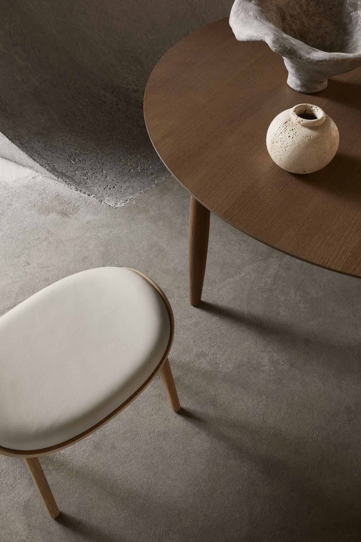 Nahaufnahme des NORR11 Elephant Ottoman Hockers mit hellem Lederbezug und Holzbeinen.