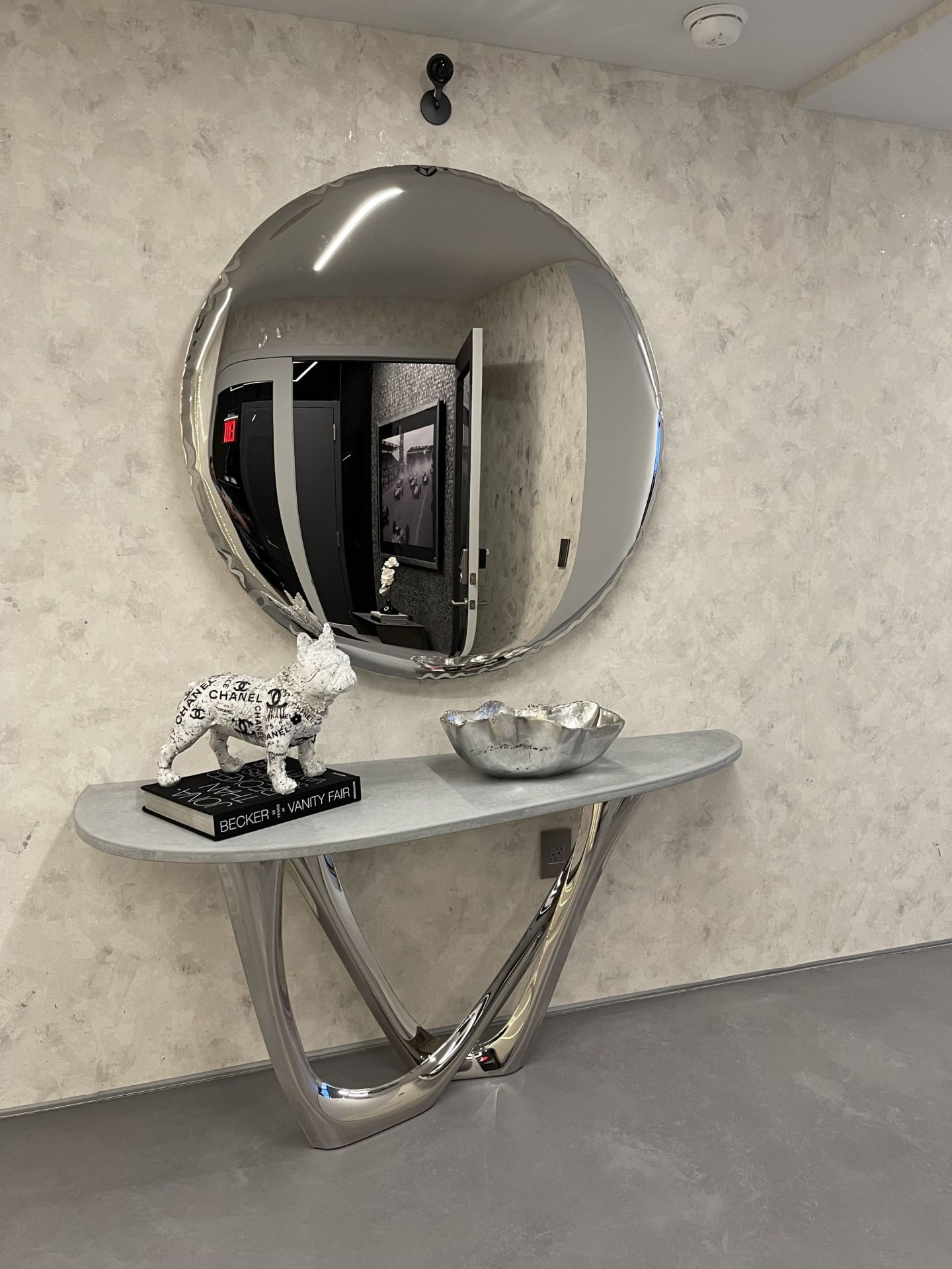 Oko inox Spiegel von Zieta, runder Design-Spiegel aus Edelstahl, reflektiert ein modernes Interieur.