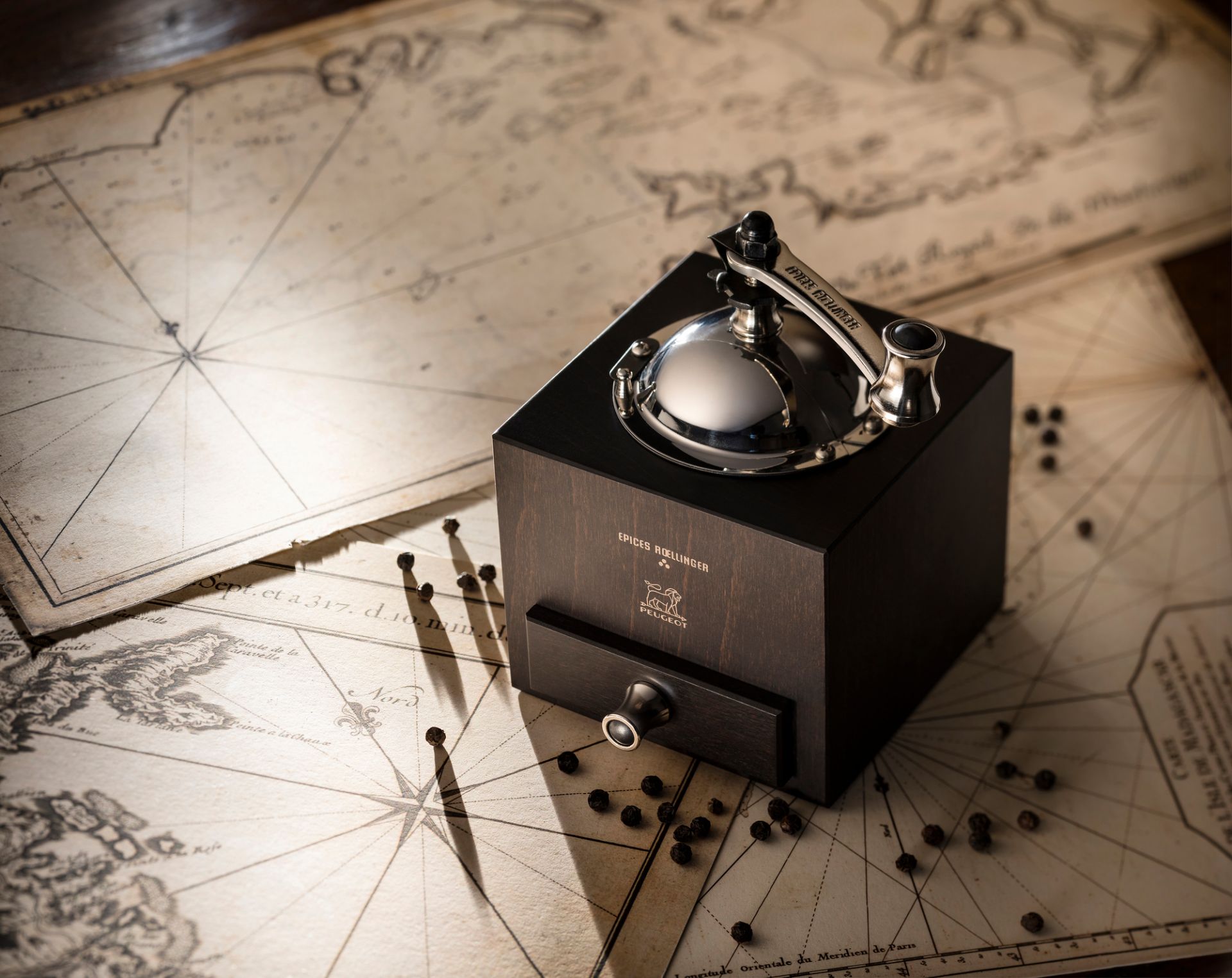 Roellinger Pfeffermühle Peugeot aus Holz mit Schublade und silbernem Mahlwerk auf alter Seekarte.