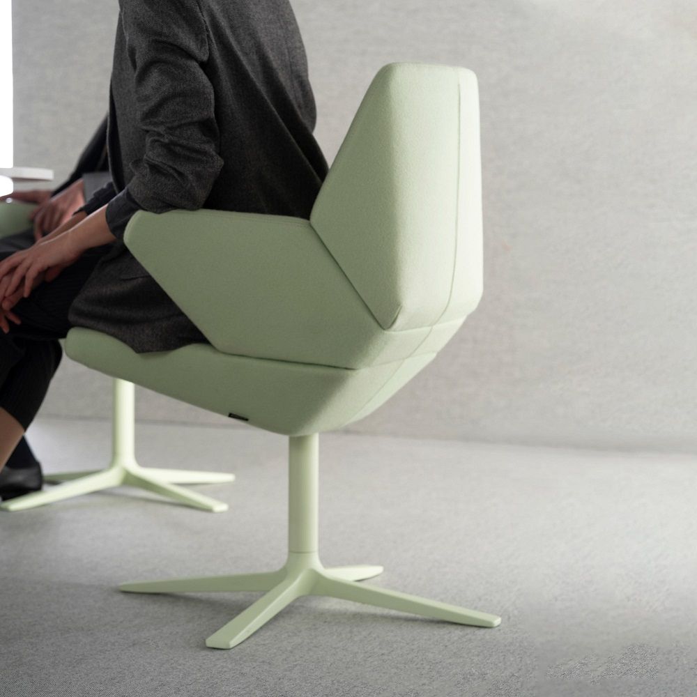 Detailaufnahme: Person sitzt auf einem hellgrünen Trifidae Armsessel von Prostoria mit Drehfuß.