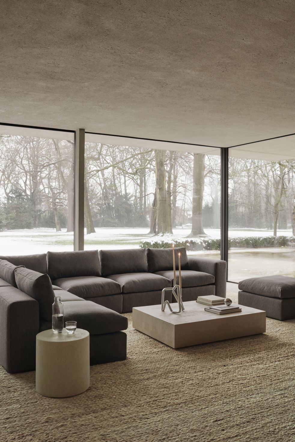 Mellow Polsterhocker in Granitgrau von Ethnicraft, passend zum Sofa, im modernen Wohnzimmer.