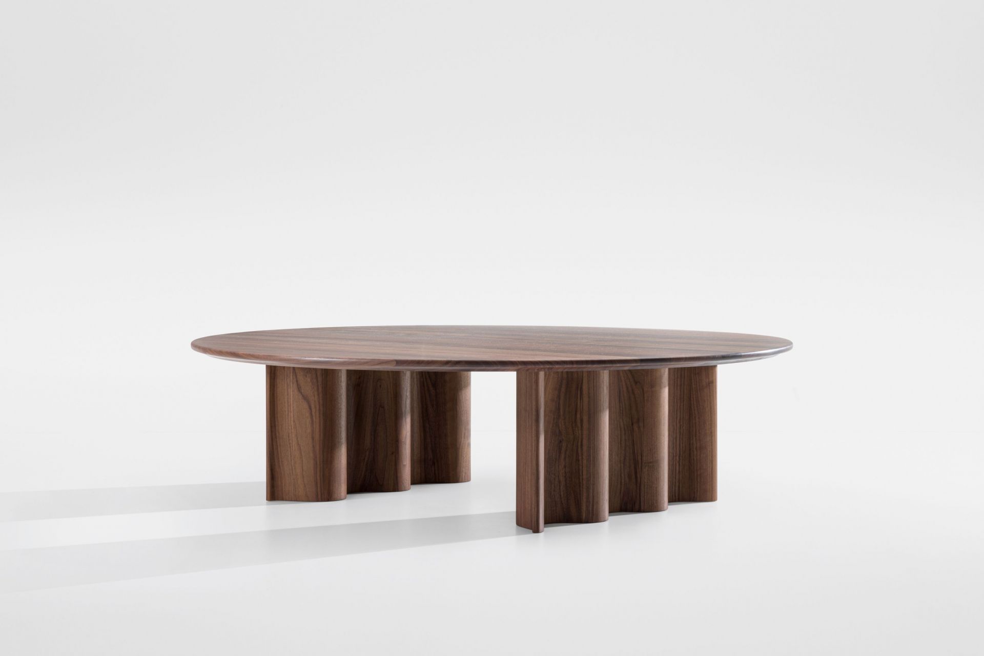 Curtain Couchtisch aus Walnuss: Runder Wohnzimmertisch mit besonderem Design und Holzfüßen.