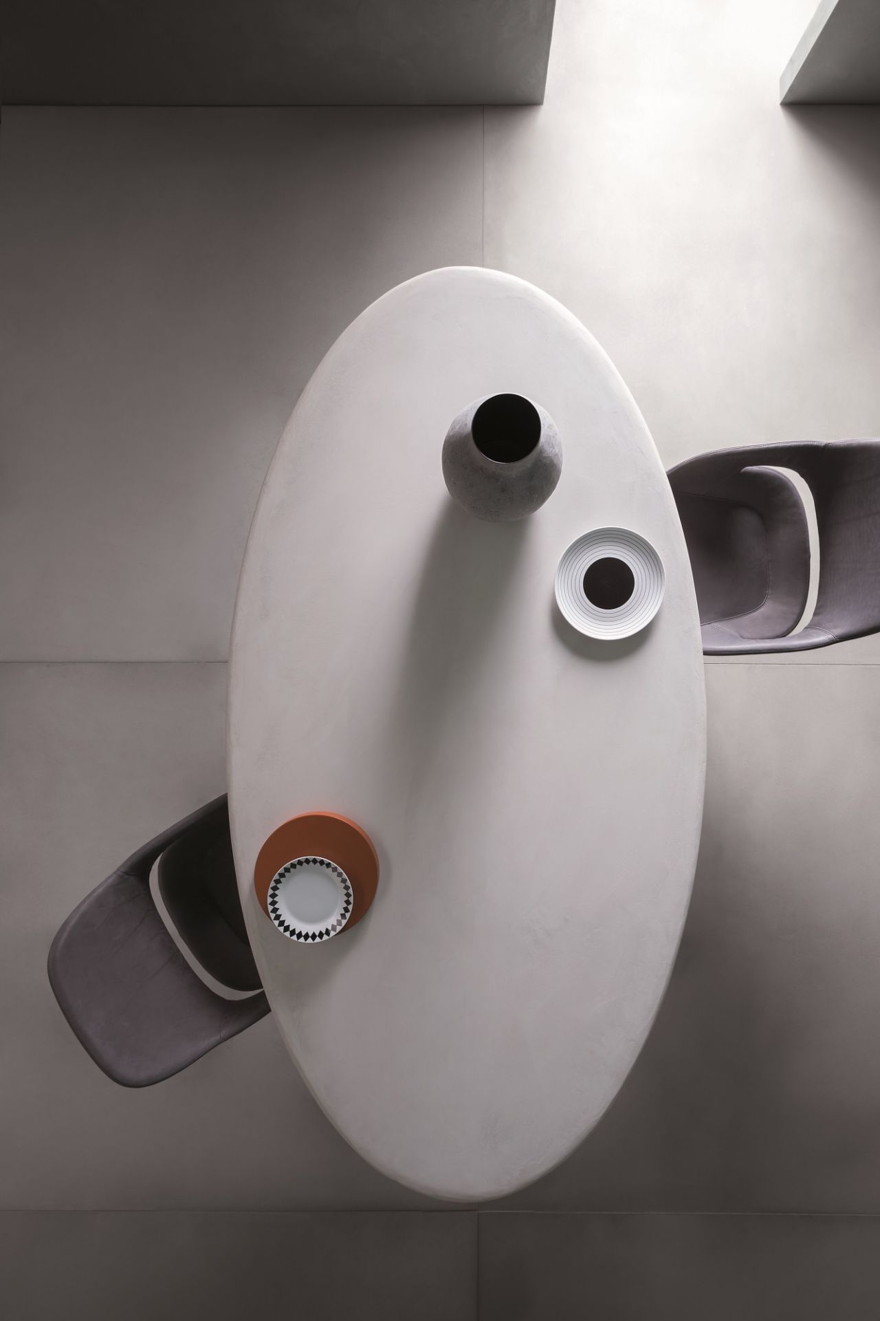 Draufsicht: Ovaler Fenice Tisch von Zanotta mit Dekoration und zwei Stühlen.