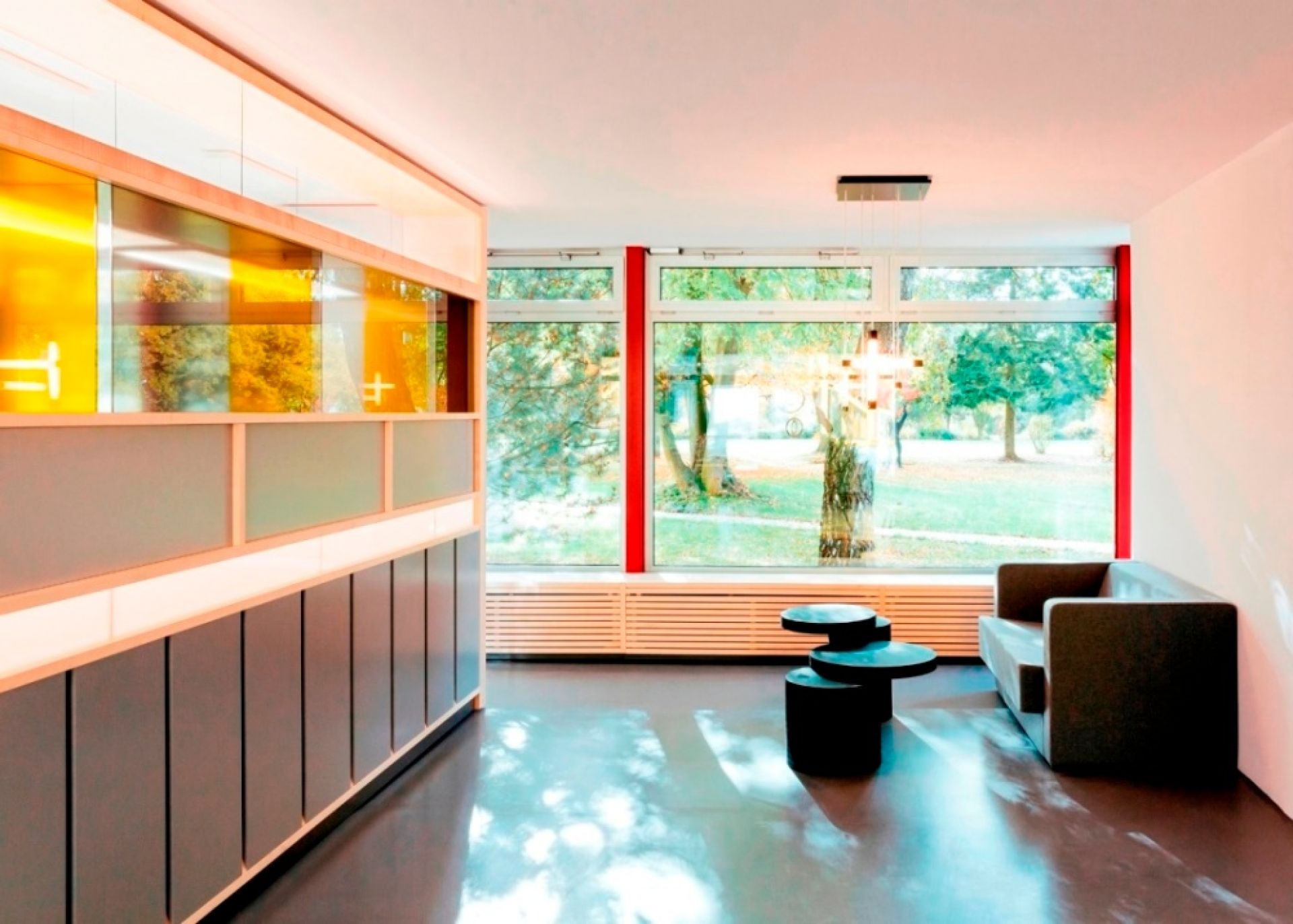 Modernes Wohnzimmer mit Tecta K8B Couchtisch, schwarzem Design, drei Ebenen und passendem Sofa.