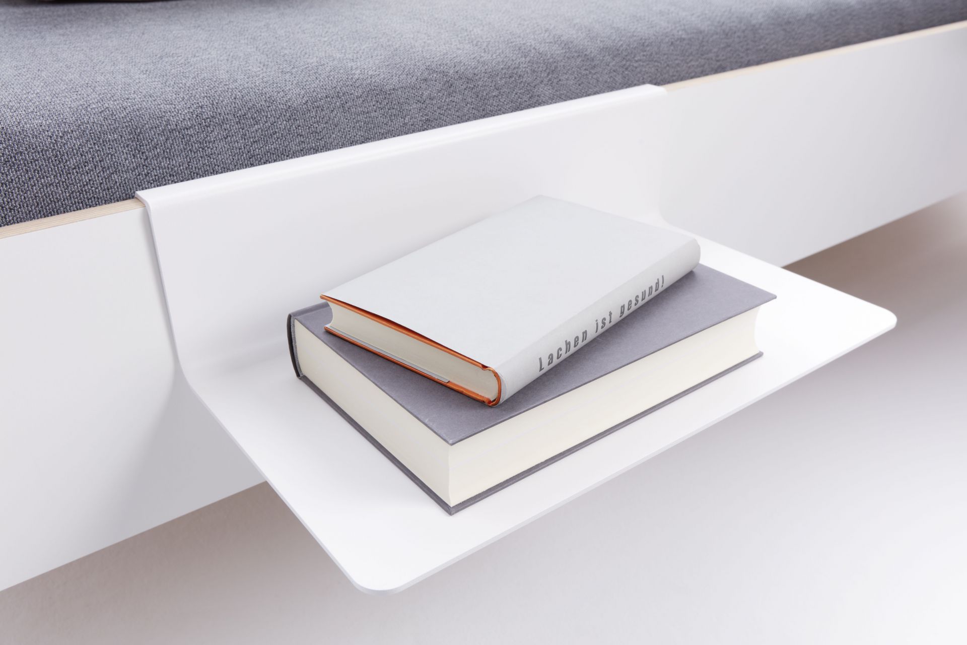 Weiße Nachttischablage für Flai Bett von Müller Möbelwerkstätten mit zwei Büchern.