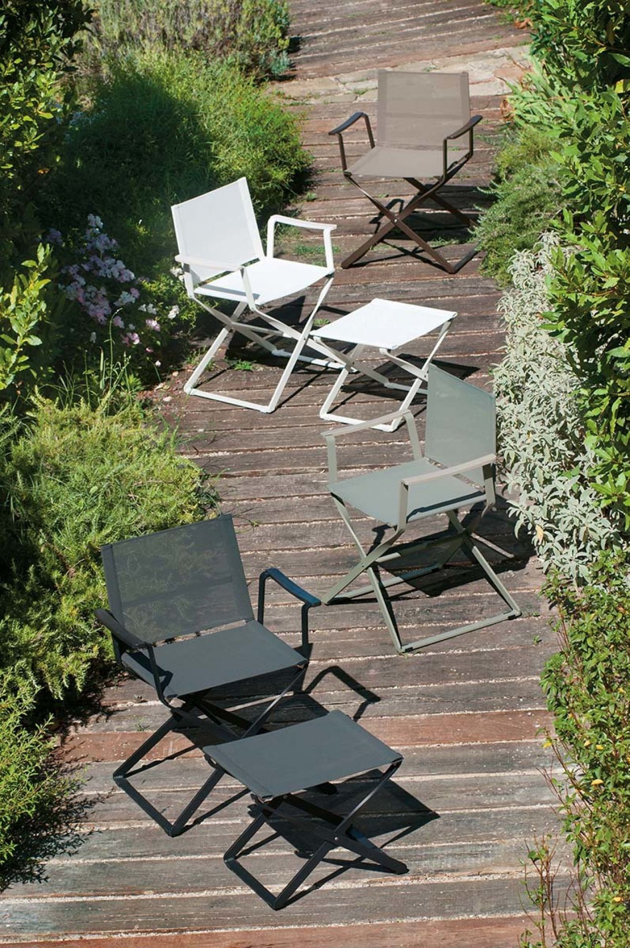 Mehrere Ciak Regiestühle von Emu in verschiedenen Farben auf einer Holzterrasse im Garten.