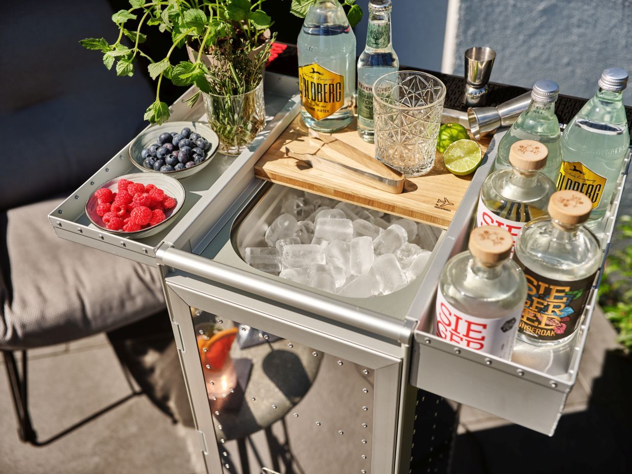 Rivet Rocker Flugzeugtrolley Bordbar mit Eis, Gin, Tonic und Beeren für Cocktails.