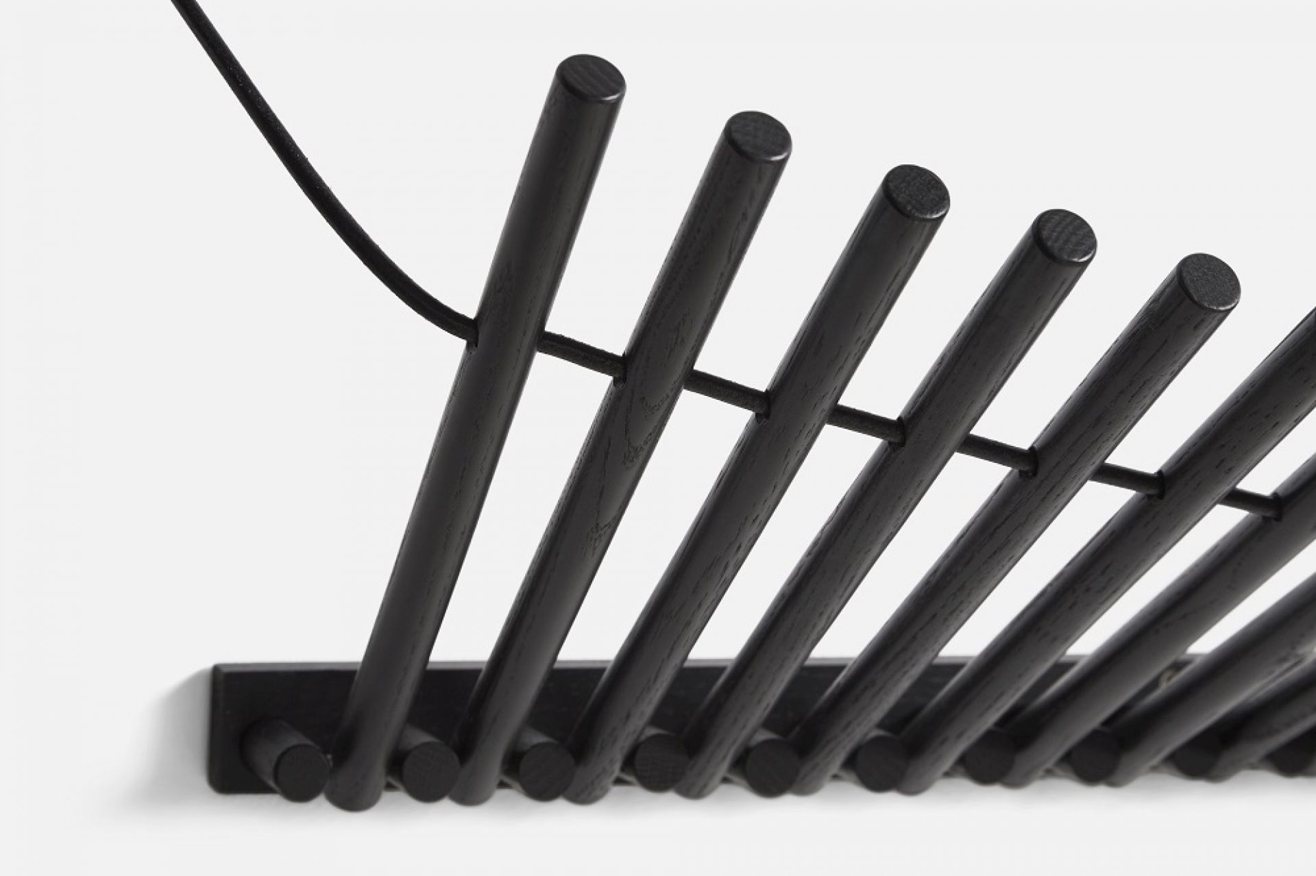 Detailaufnahme der Knaegt Wandgarderobe von Woud aus schwarzem Eichenholz, moderne Garderobenlösung für Flur und Eingangsbereich.