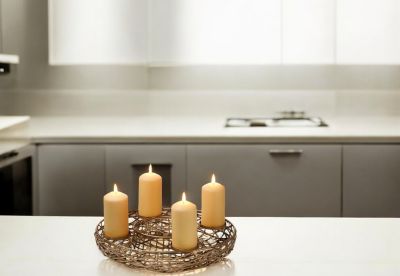 Adventskranz mit vier eleganten Kerzen in einem modernen Korbdesign, ideal für festliche Dekoration.