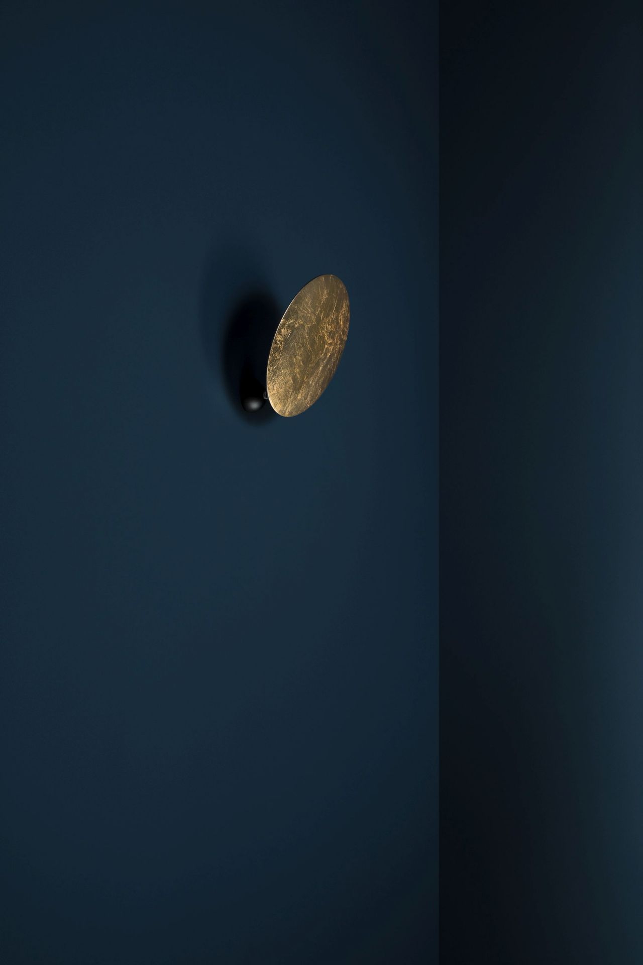 Goldene Lederam Wandleuchte von Catellani & Smith an blauer Wand, modernes Design.