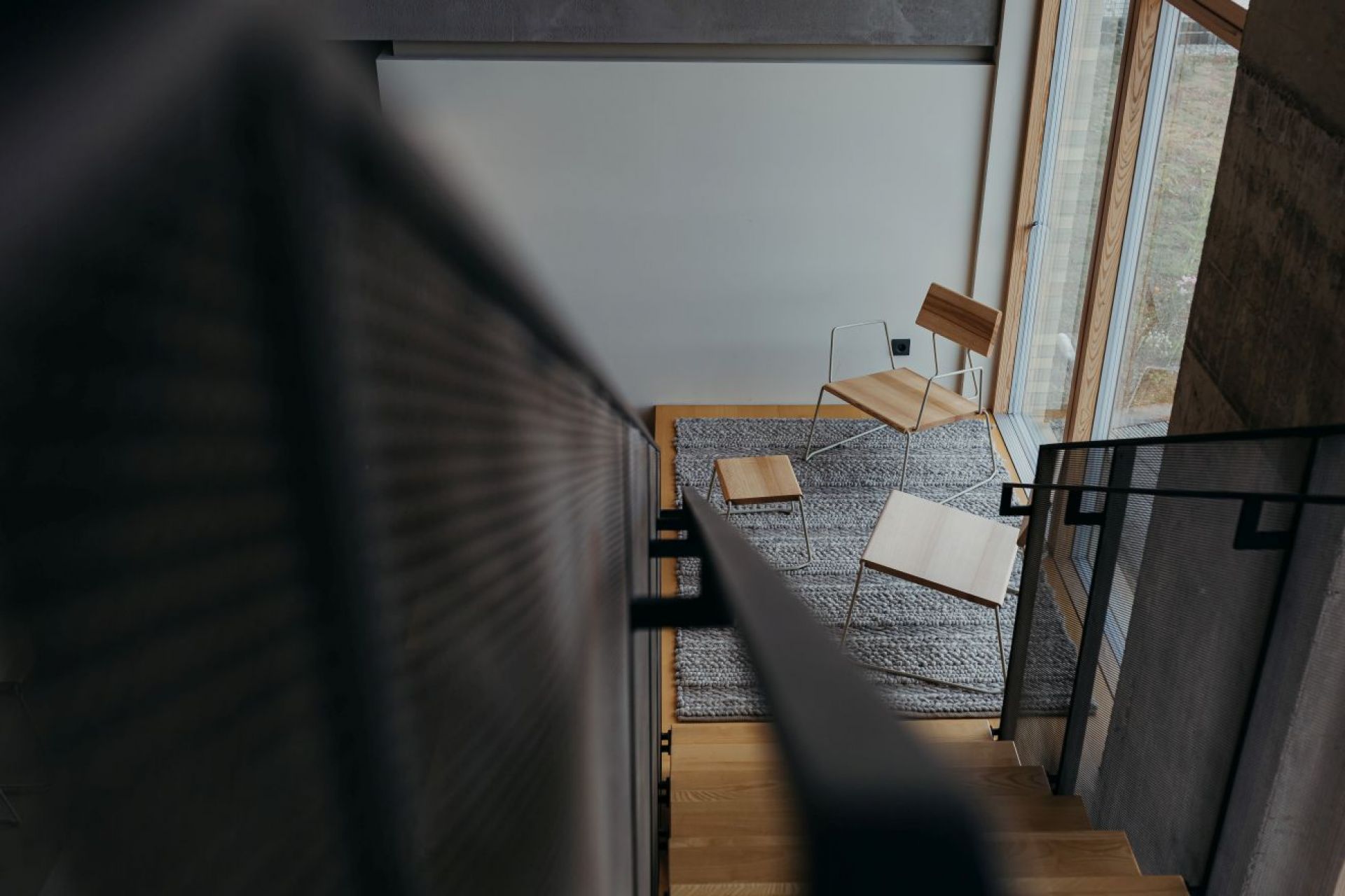 D:002 Beistelltisch Ultraviolett Fuchs & Habicht neben Stühlen auf grauem Teppich, gesehen von Treppe.