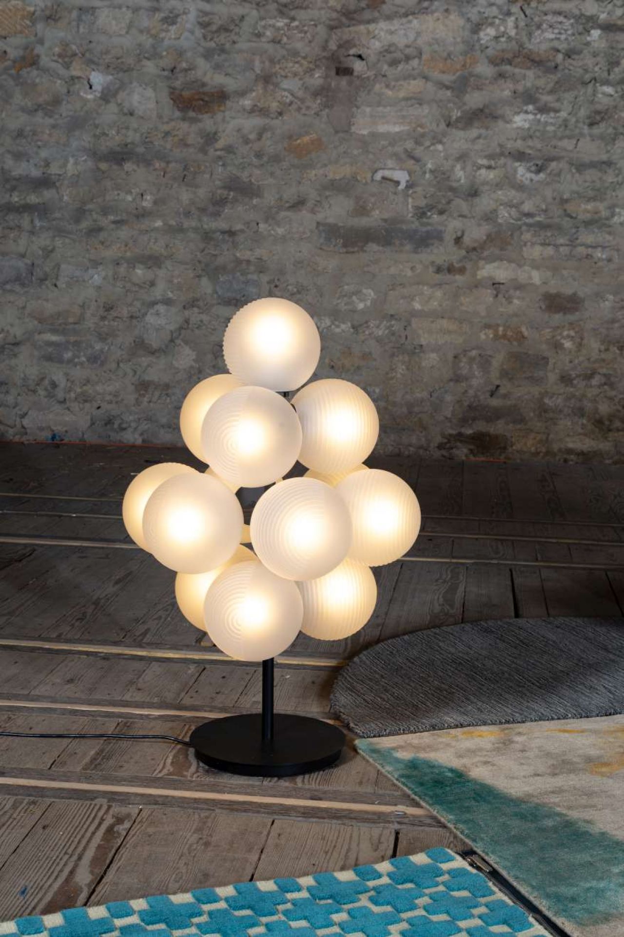 Stellar Grape Tischleuchte von Pulpo: Moderne Designlampe mit kugelförmigen Leuchtkörpern auf schwarzem Fuß.