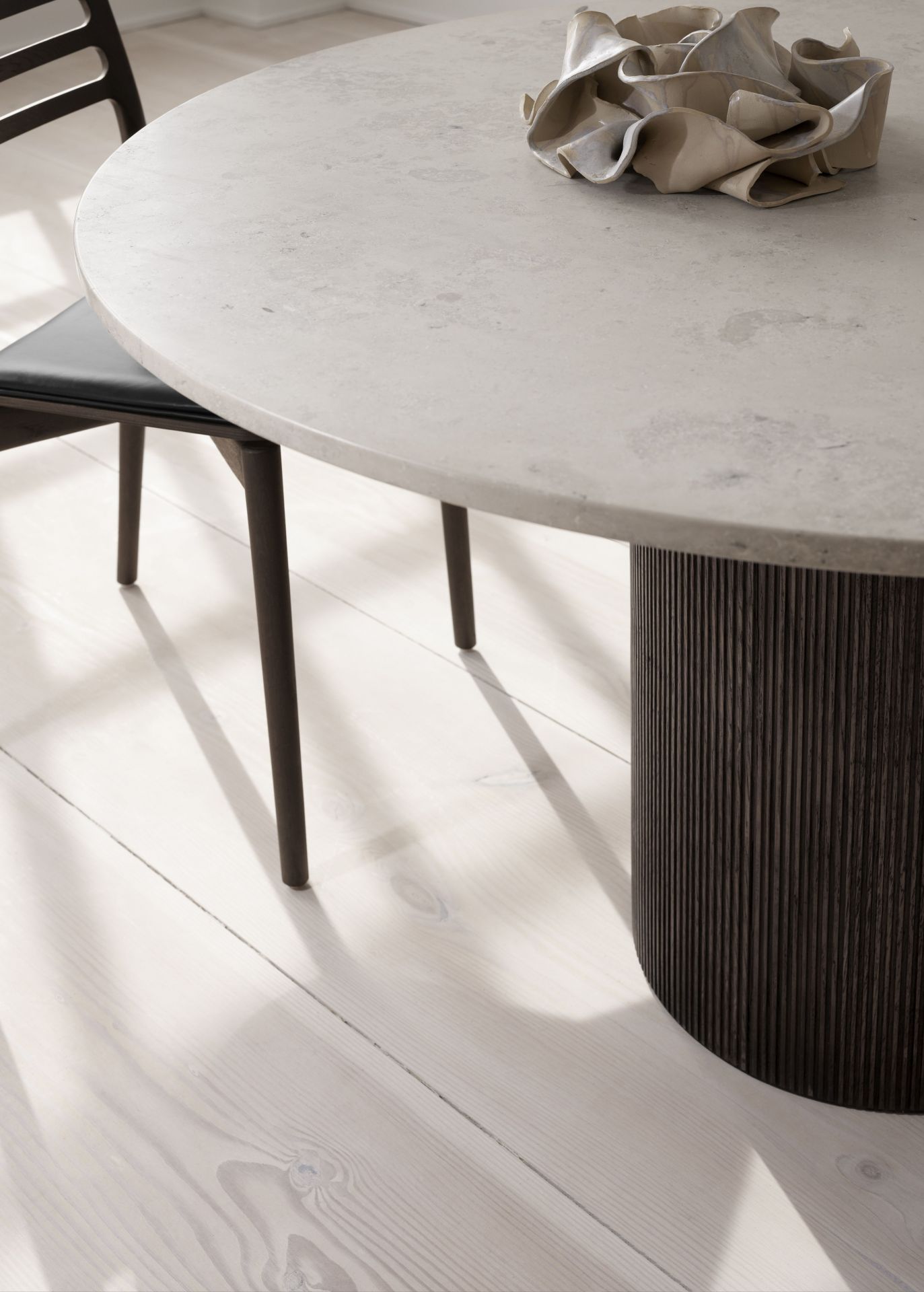 Nahaufnahme des Vipp Cabin Tisch rund in dunkler Eiche mit Keramikobjekt.