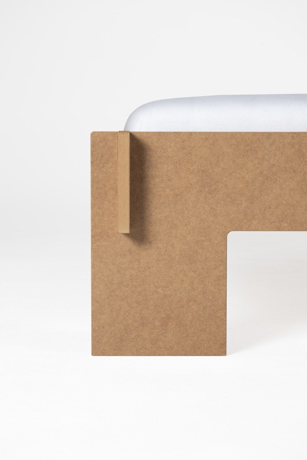 Detailaufnahme vom Siebenschläfer Bett von Moormann, MDF Natur, mit Kopfteil und weißer Bettwäsche.