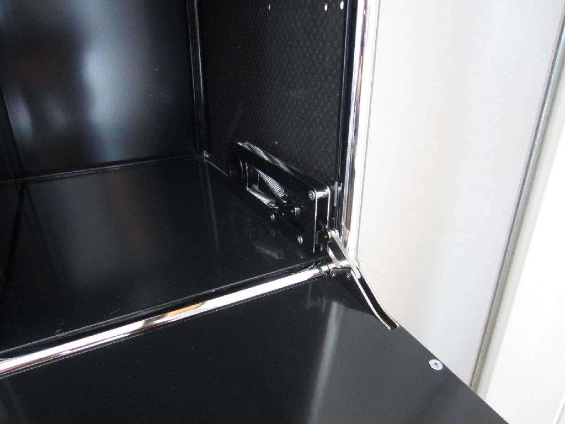 Detailaufnahme: USM Haller Klappe in Stahlblau, Ersatzteil mit Scharnier und Feder für modulare Möbel.