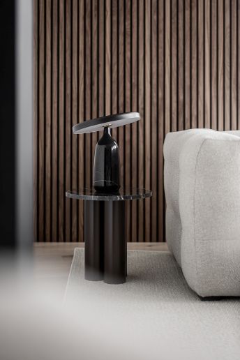 Normann Copenhagen Dit Coffee Table Beistelltisch mit Marmorplatte und schwarzem Sockel neben Sofa.