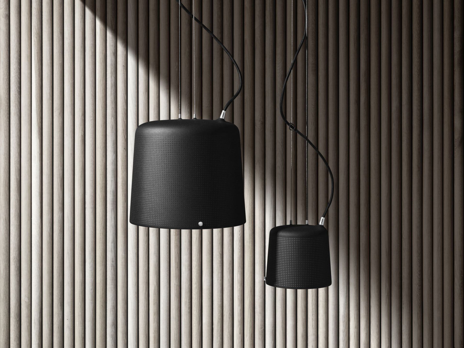 Zwei schwarze Vipp Pendelleuchten, moderne Hängelampen für Wohnzimmer und Esszimmer, vor einer Holzpaneelwand.