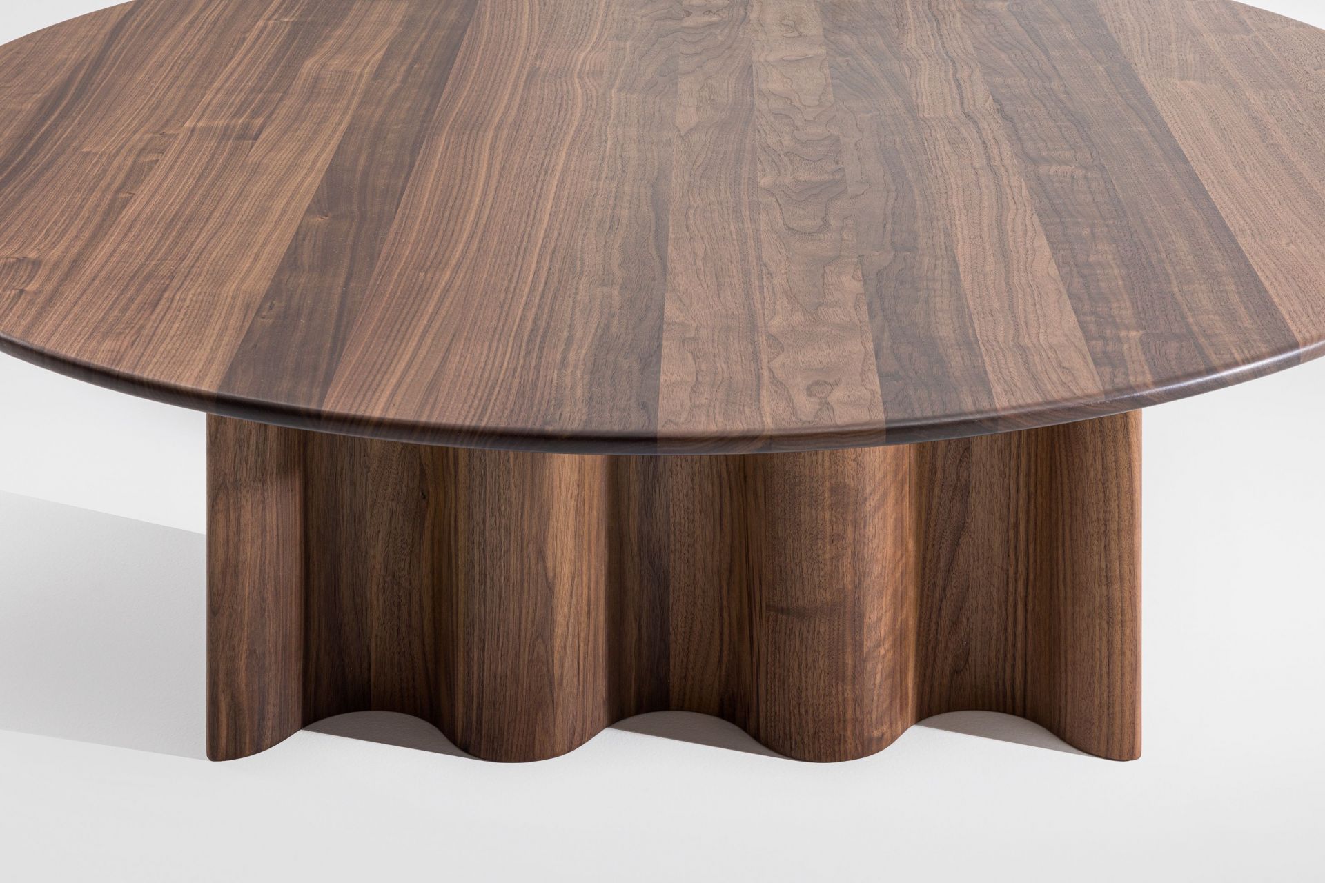 Runder Couchtisch aus Walnussholz mit geriffelter Basis. Modernes Design für Wohnzimmer und Wartebereiche.