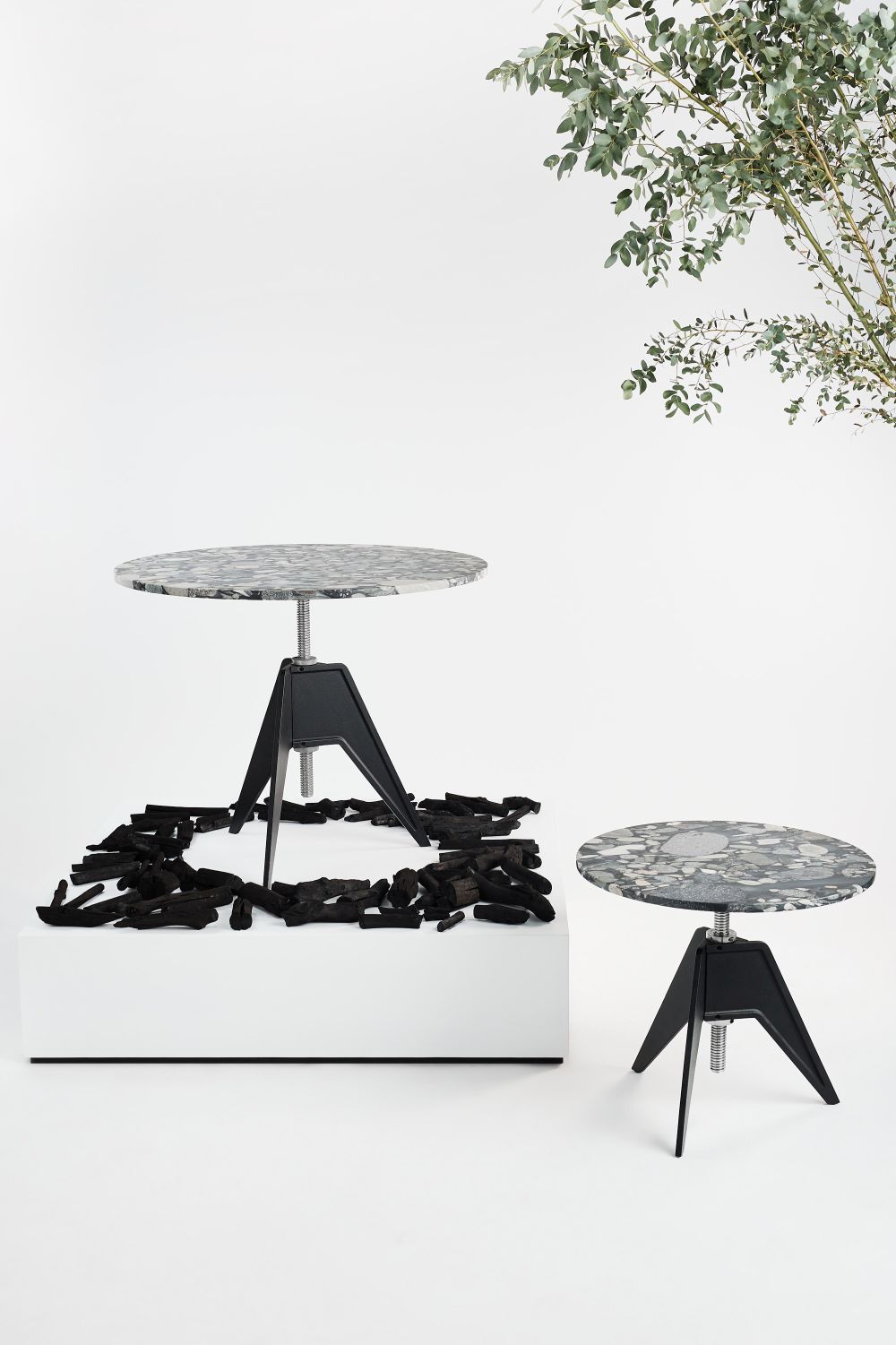 Zwei Screw Beistelltische von Tom Dixon mit runder Tischplatte und schwarzem Metallfuß.