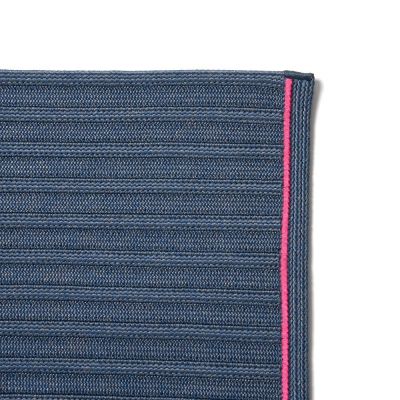 Detailansicht: Blauer South Outdoor Teppich mit pinkfarbener Kante, ideal für Terrasse und Garten.