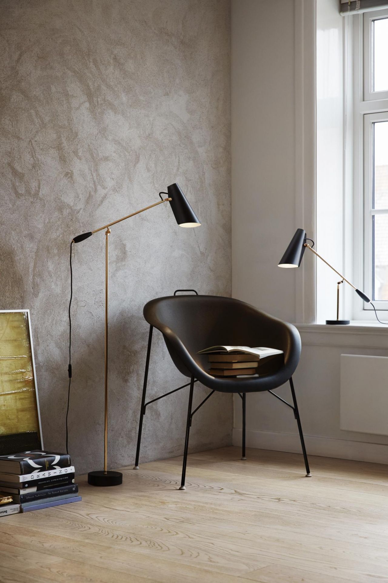 Birdy Stehleuchte und Tischleuchte in Schwarz und Gold im modernen Interieur. Designleuchten für Wohnzimmer.