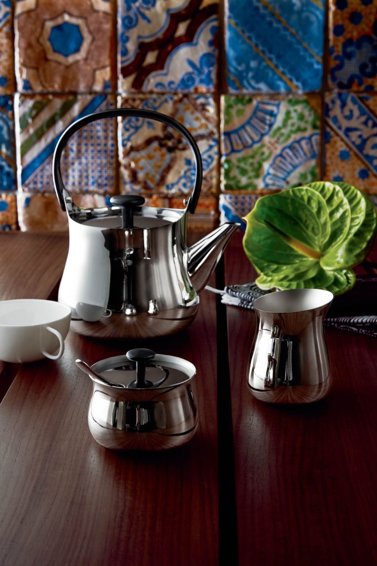 Nahaufnahme des Alessi NF02 Rahmkännchens Cha aus Edelstahl mit Teekanne und Zuckerdose.