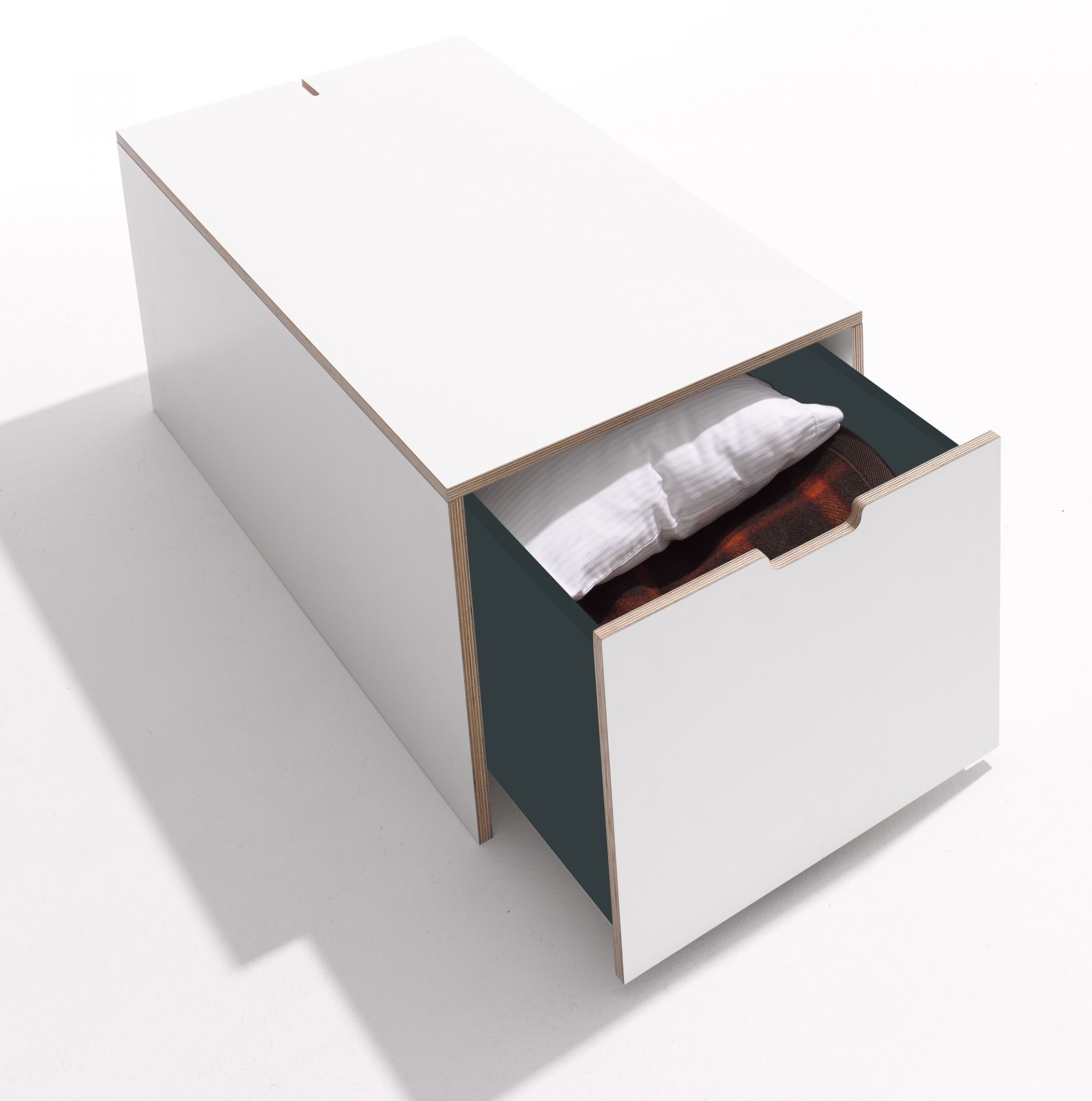 Weißer Klassik Bettkasten von Müller Möbelwerkstätten mit offenem Schubkasten, gefüllt mit Kissen und Decke.