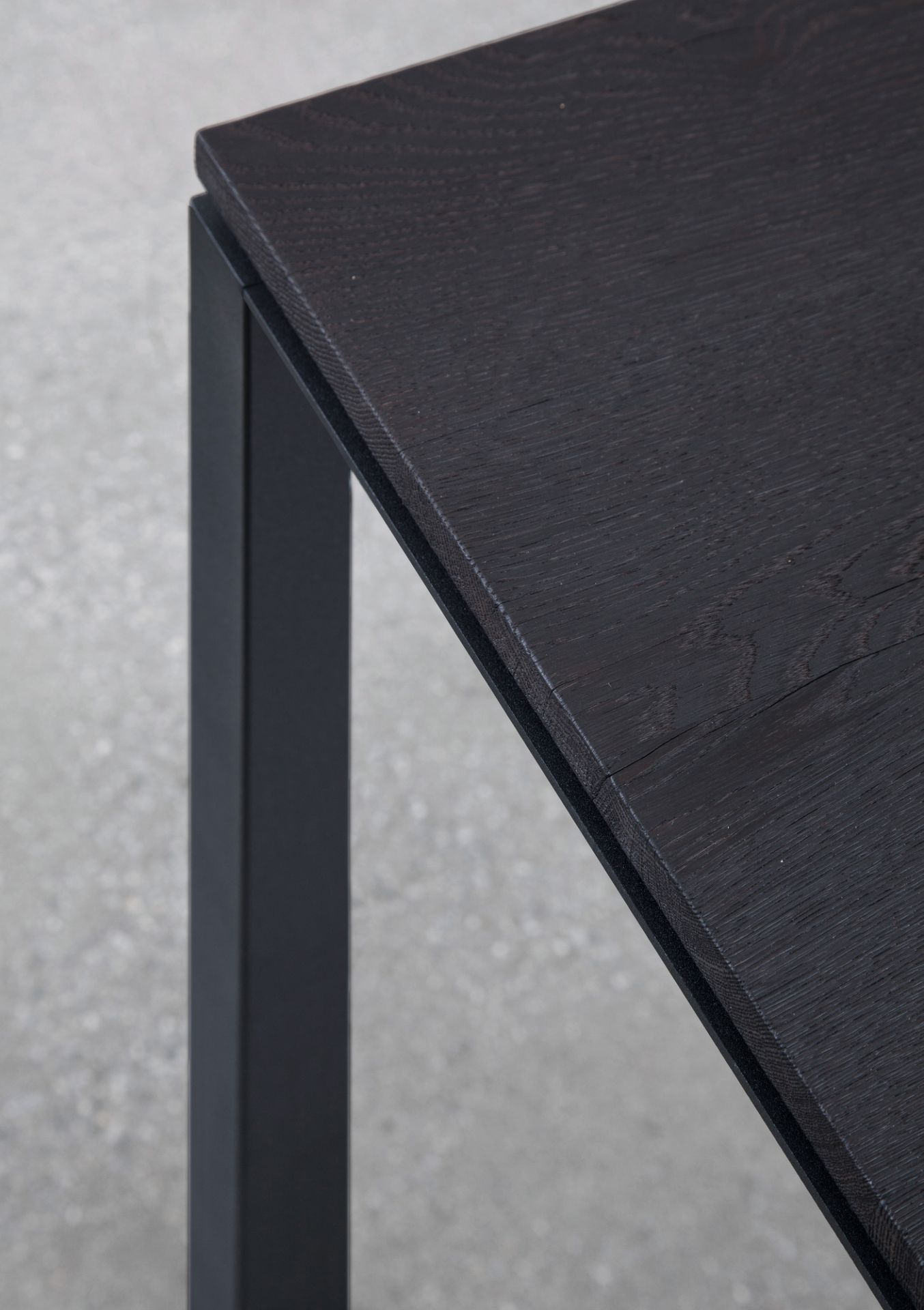 Detailaufnahme S 600 Tisch von Janua: Geköhlte Eiche Tischplatte mit schwarzem Metallgestell.