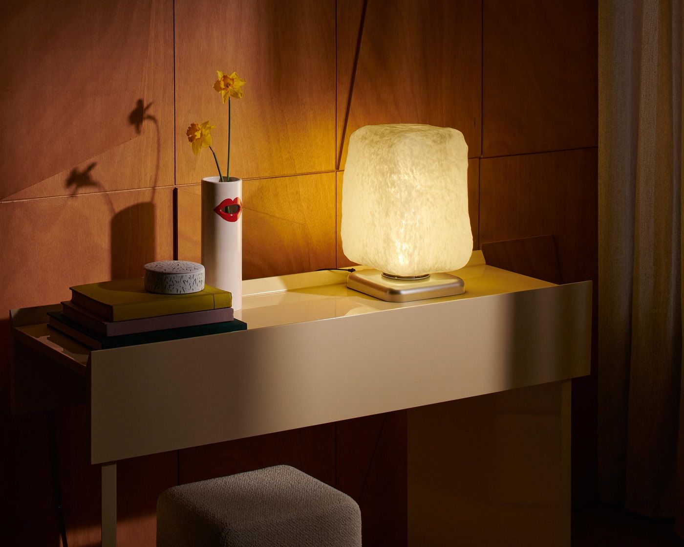Nahaufnahme der Cassina Stone Light Tischleuchte auf einem Schreibtisch, warmes Licht, modernes Design.