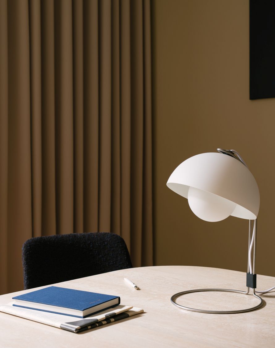 FlowerPot VP4 Tischleuchte von AndTradition in Weiß auf einem Schreibtisch mit Notizbuch.