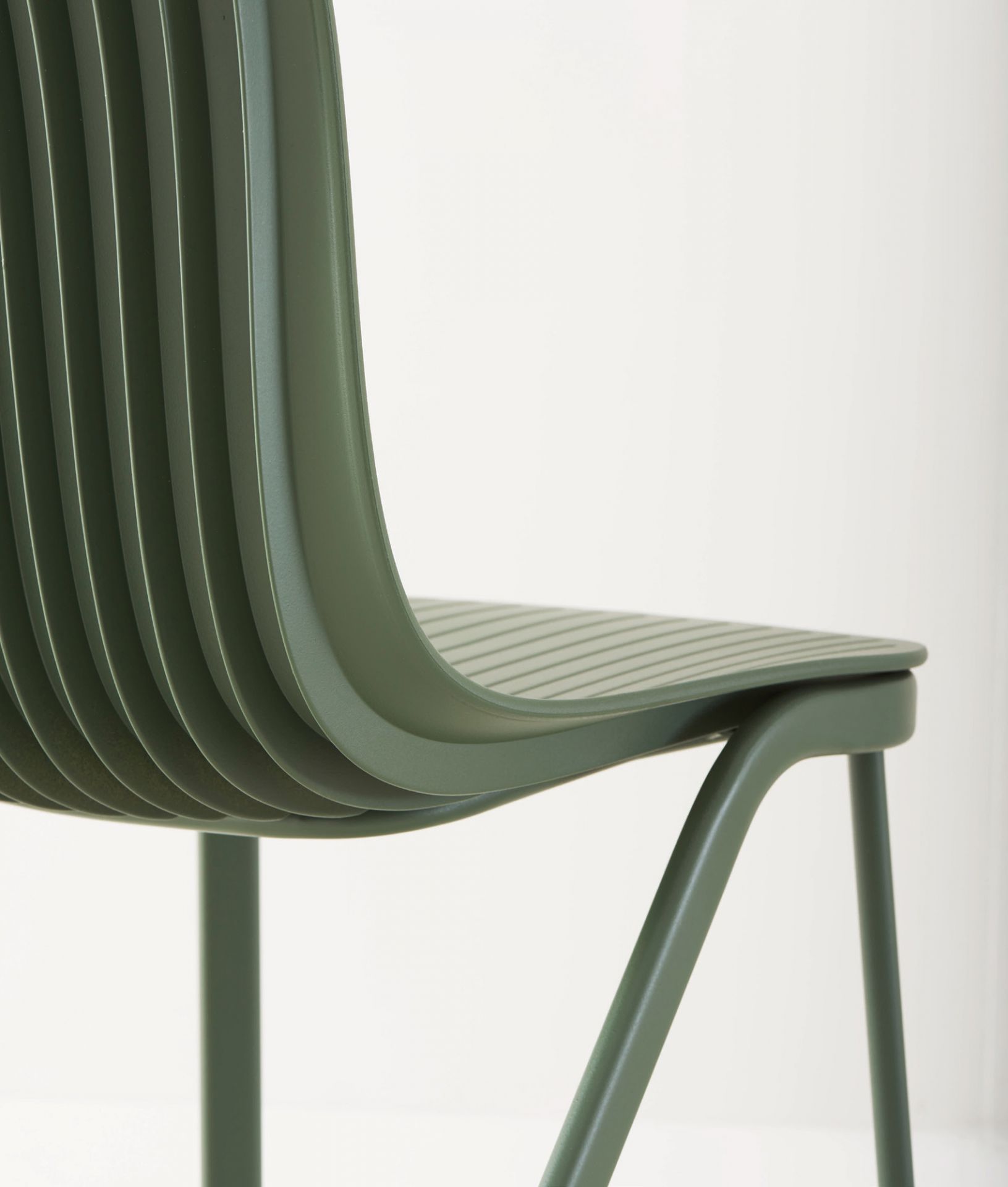 Detailaufnahme: Grüner Dragonfly Stuhl mit Metallbeinen, modernes Design für Esszimmer und Büro.