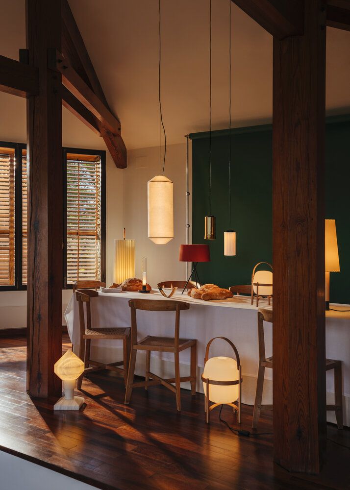 Cestita Batería Akkuleuchte von Santa & Cole auf einem Esstisch, warmes Licht, modernes Design.