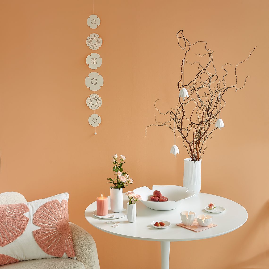 Dekorative "Das Blühende Leben" Schale von Räder auf Tisch mit Blumen, Kerzen und Ästen in Vase.