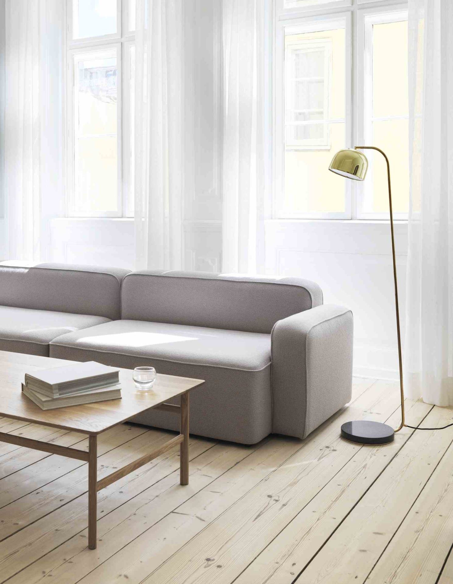 Moderner Wohnraum mit grauem Sofa und Grow Table Couchtisch von Normann Copenhagen aus dunkler Eiche.