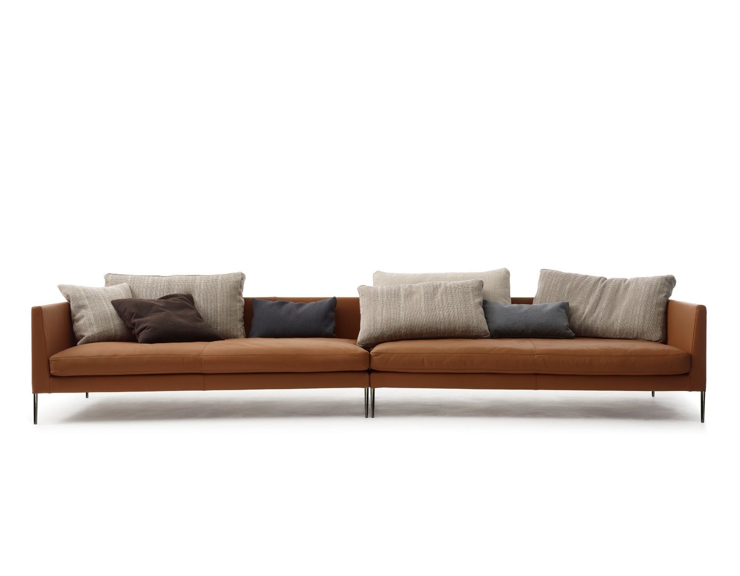 Braunes Pilotis Sofa von Cor ohne Rückenkissen, mit Zierkissen auf schwarzen Füßen.