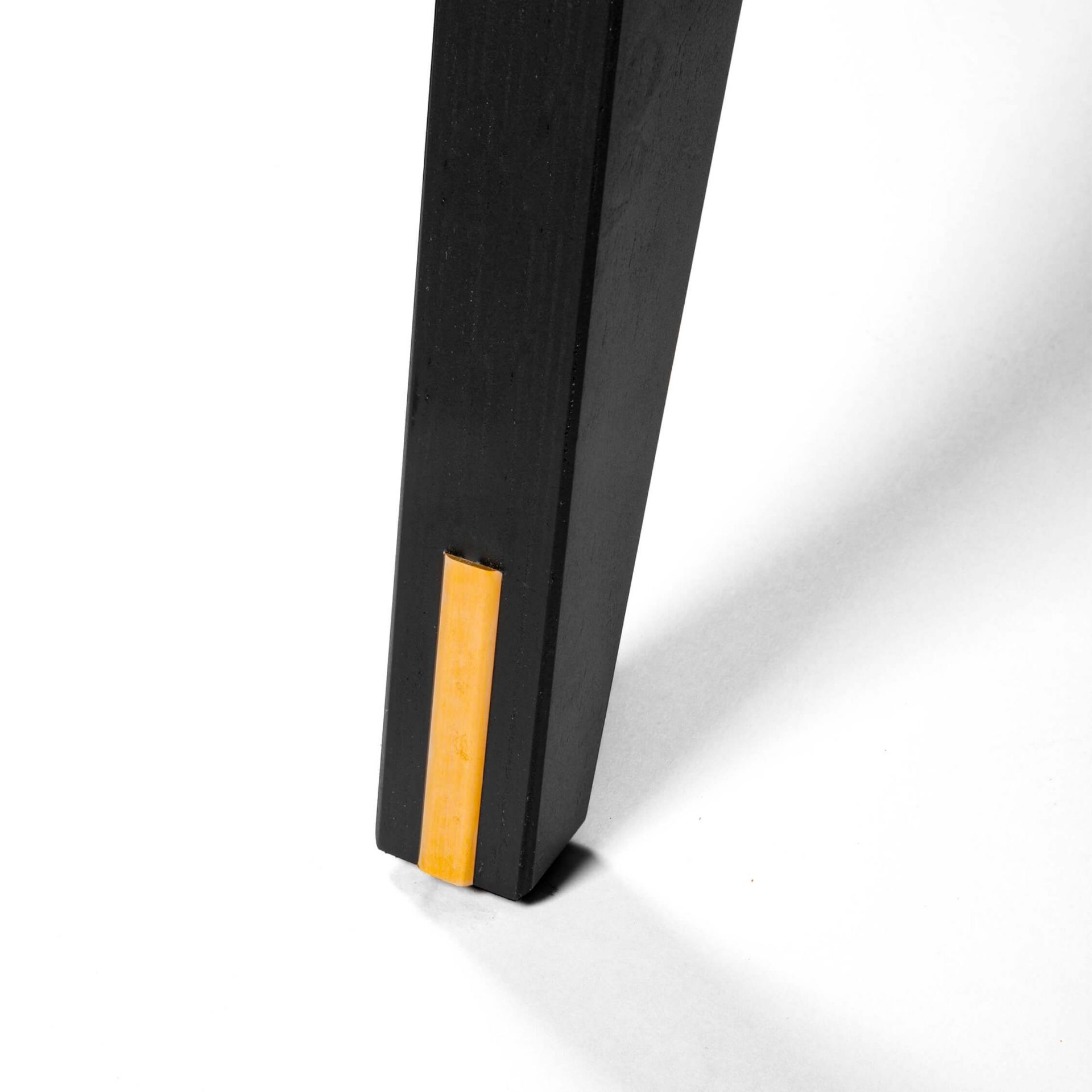 Detailaufnahme eines schwarzen Tischbeins mit goldener Verzierung vom Seletti Toiletpaper Round Table Esstisch.