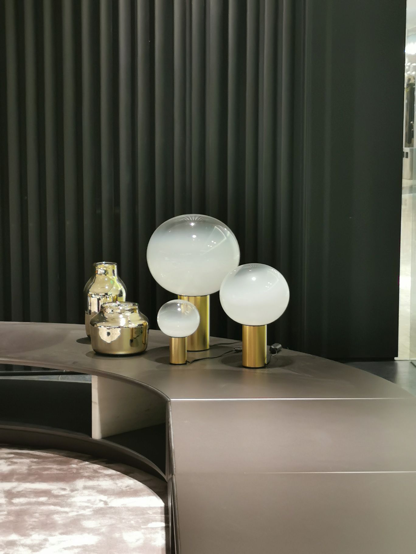 Laguna Tischleuchte von Artemide in Bronze mit drei runden Lampenschirmen und goldfarbenen Sockeln.