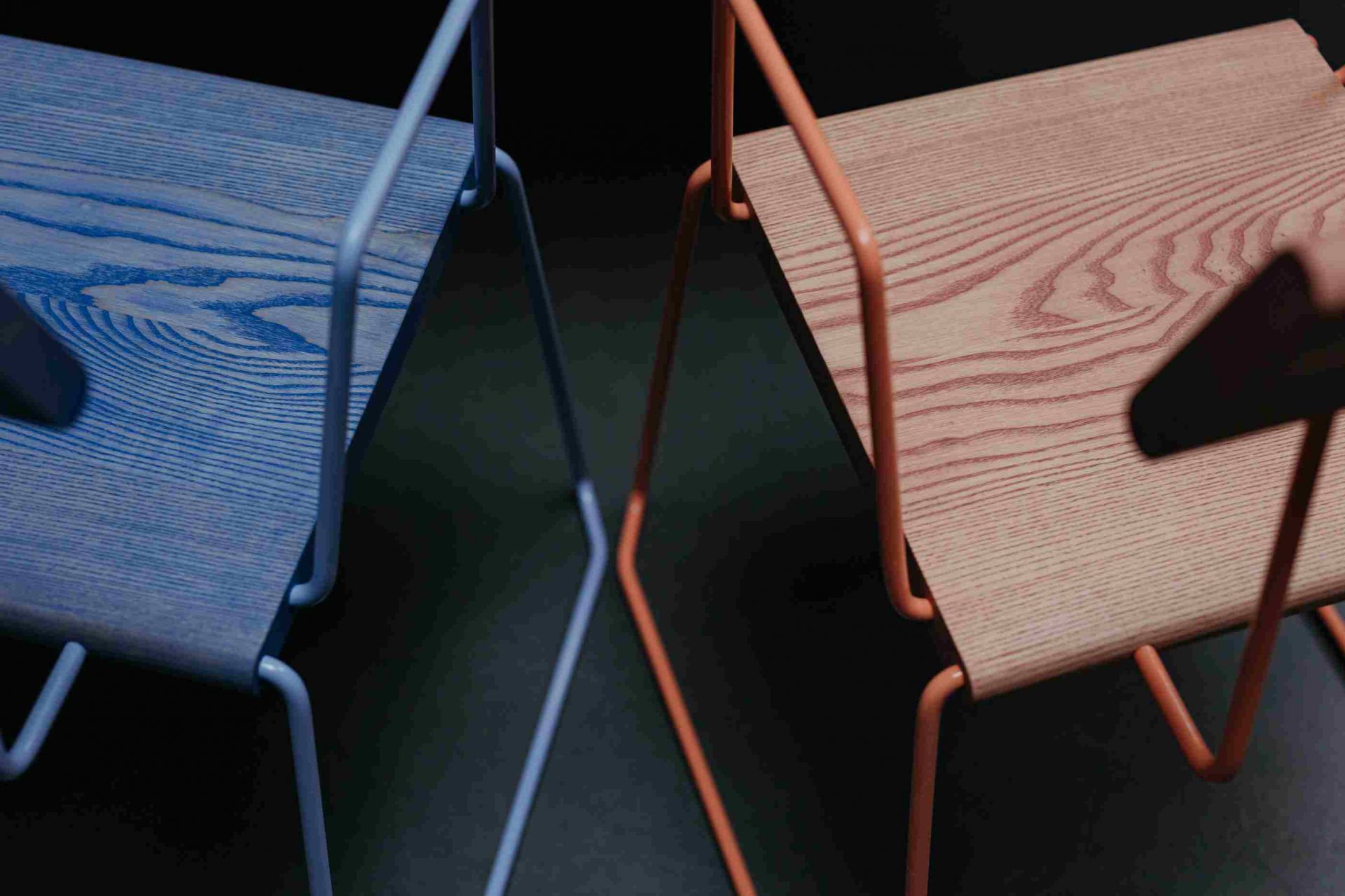 Detailaufnahme von zwei D:006 Stühlen mit Armlehnen, einer in Waldgrün, einer in Fuchs & Habicht.