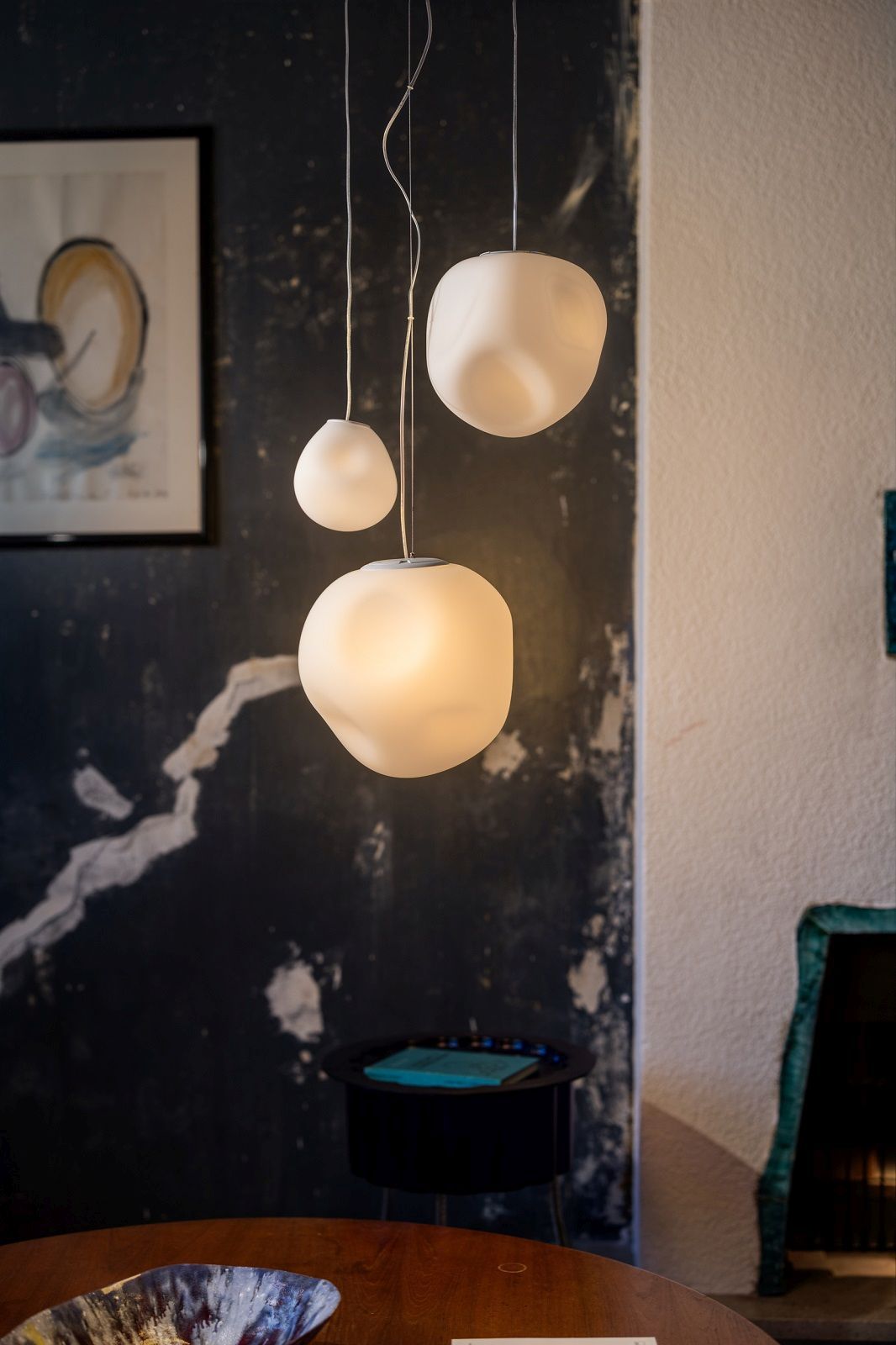 Hoba Pendelleuchte von Foscarini: Drei weiße Hängelampen in unterschiedlichen Größen im Raum.