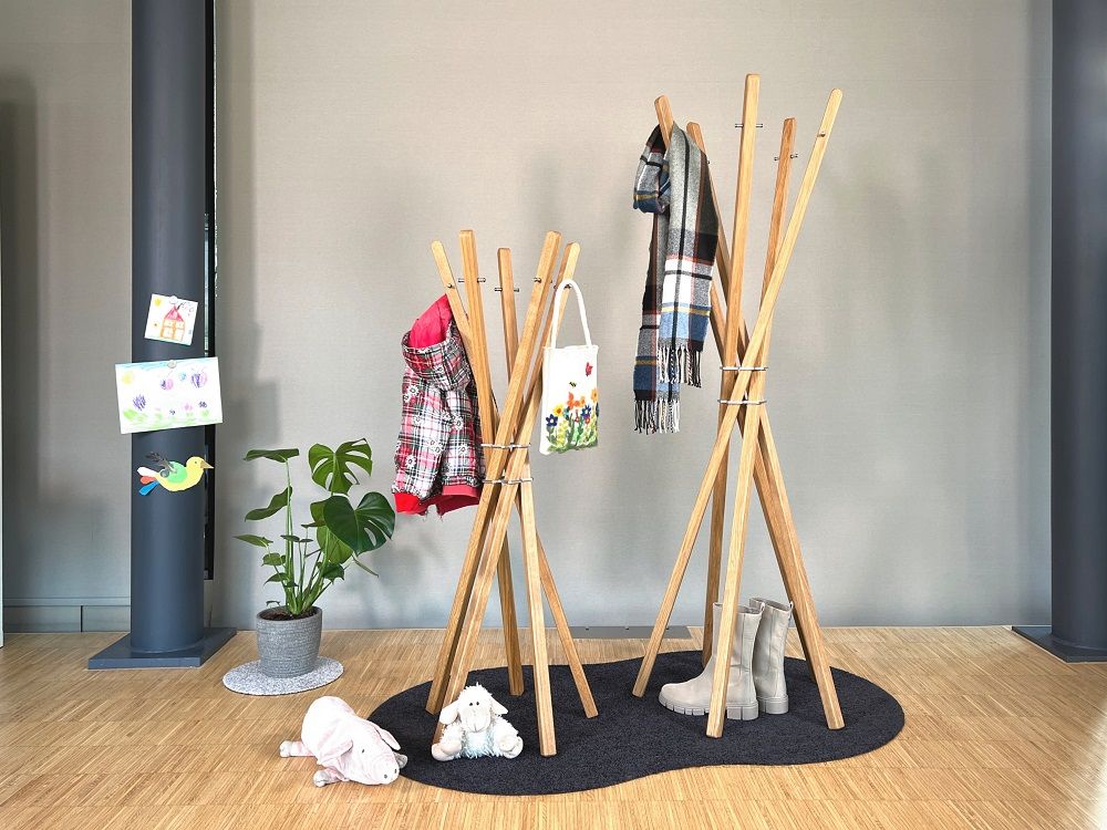 Zwei hölzerne Mary for Kids Garderobenständer im Kinderzimmer mit Kleidung und Accessoires.