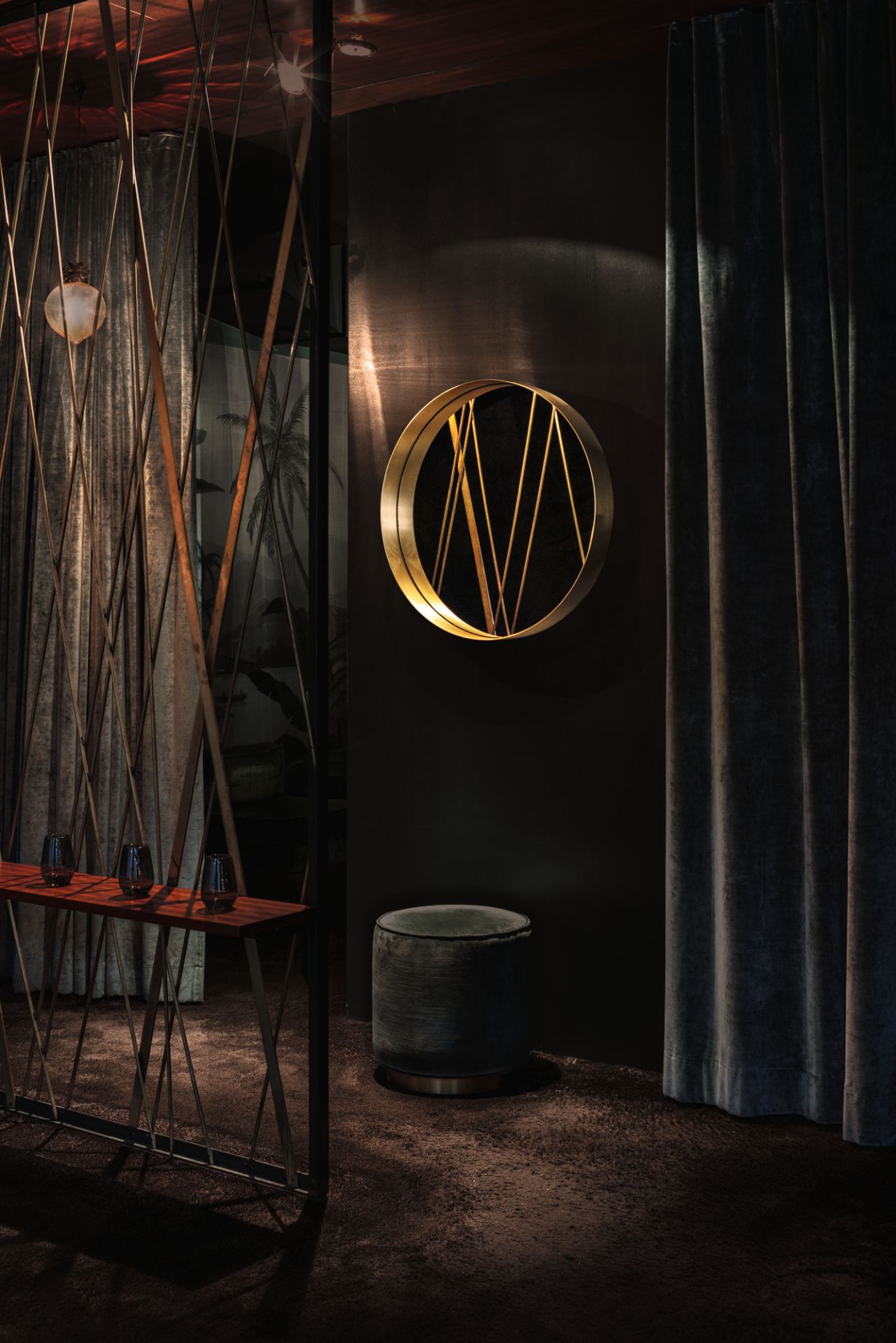 Cypris Mirror Wandspiegel von Classicon: Runder Spiegel mit Messingrahmen und geometrischen Linien an dunkler Wand.