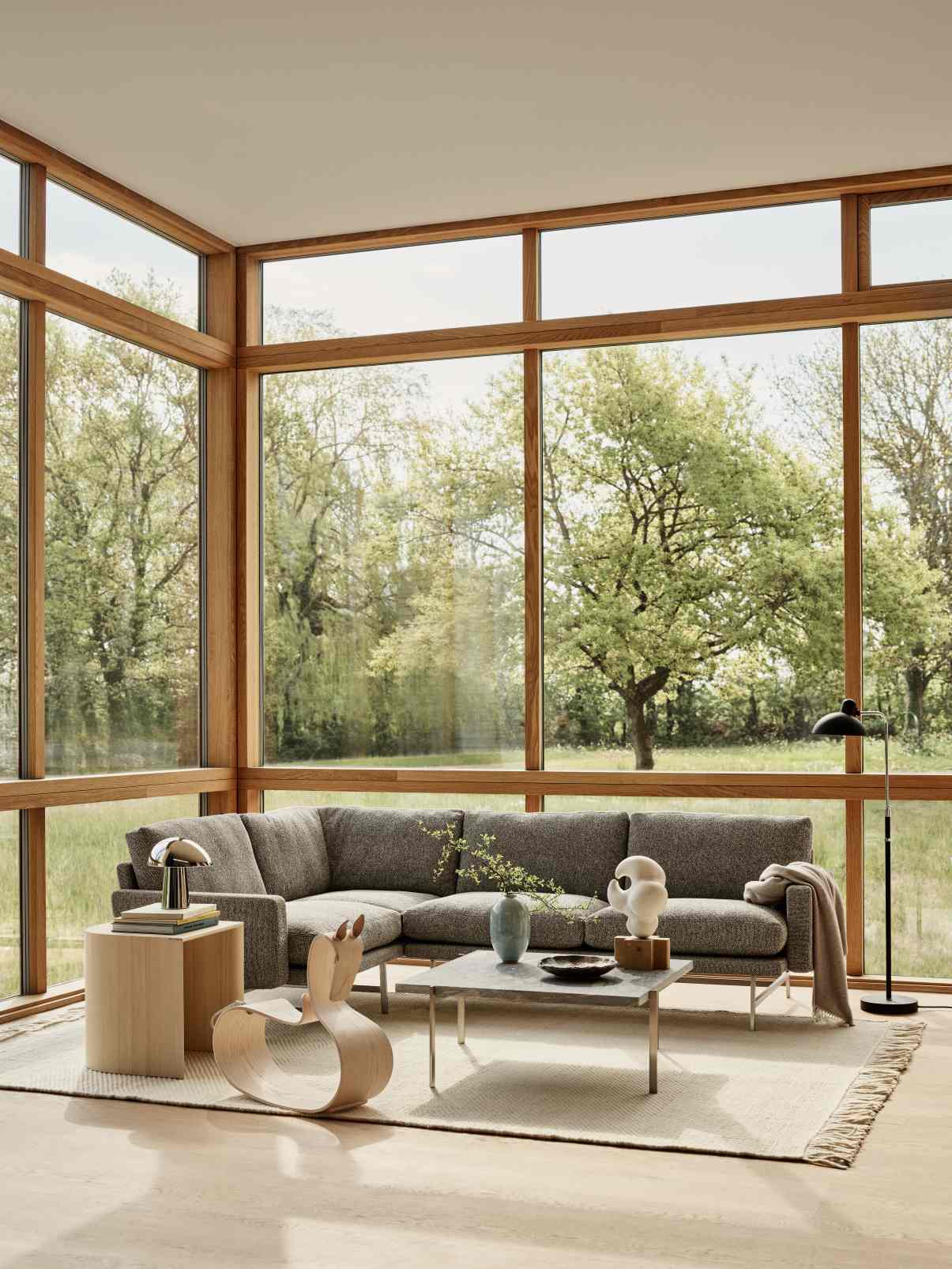 Wohnzimmer-Szene mit Fritz Hansen Taburet Hocker aus hellem Holz als Beistelltisch.