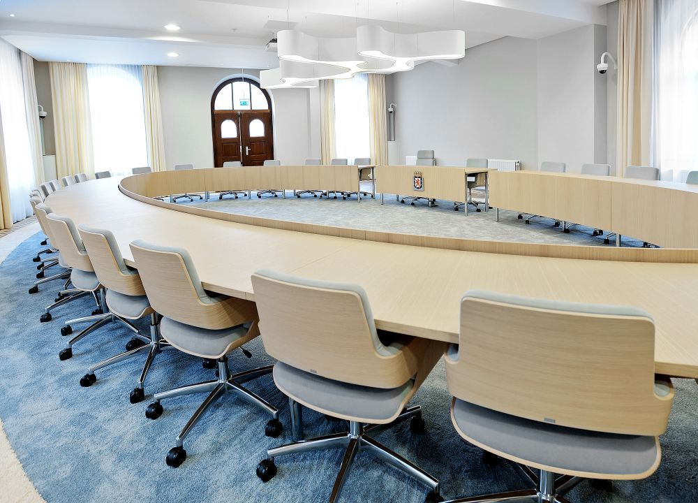 Innenraum mit ovalem Tisch und Thonet S 845 DRW Drehsesseln mit grauem Bezug und Rollen.