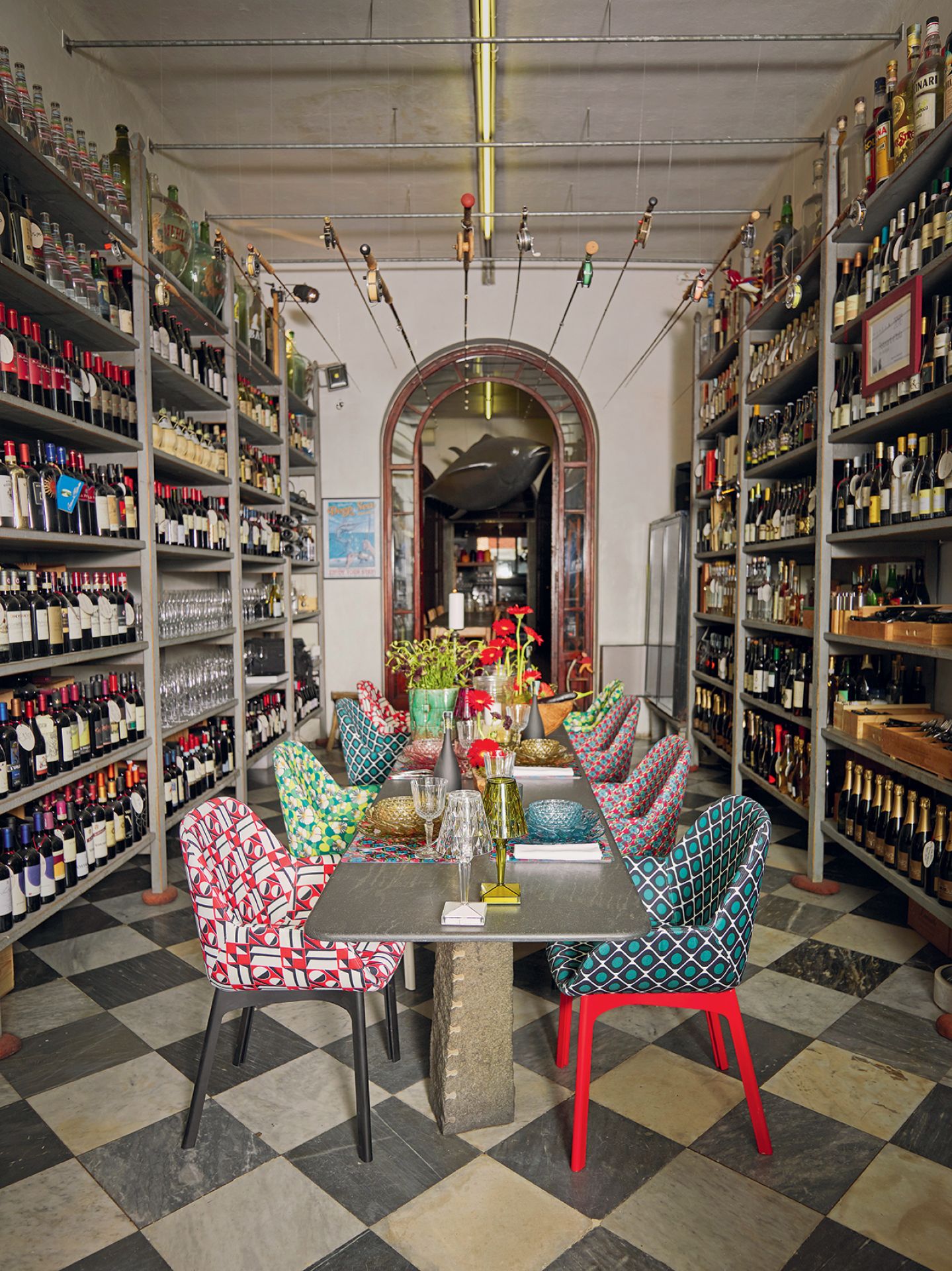 Nahaufnahme der Kartell Big Battery Tischleuchte auf einem gedeckten Tisch in einem Weinladen.