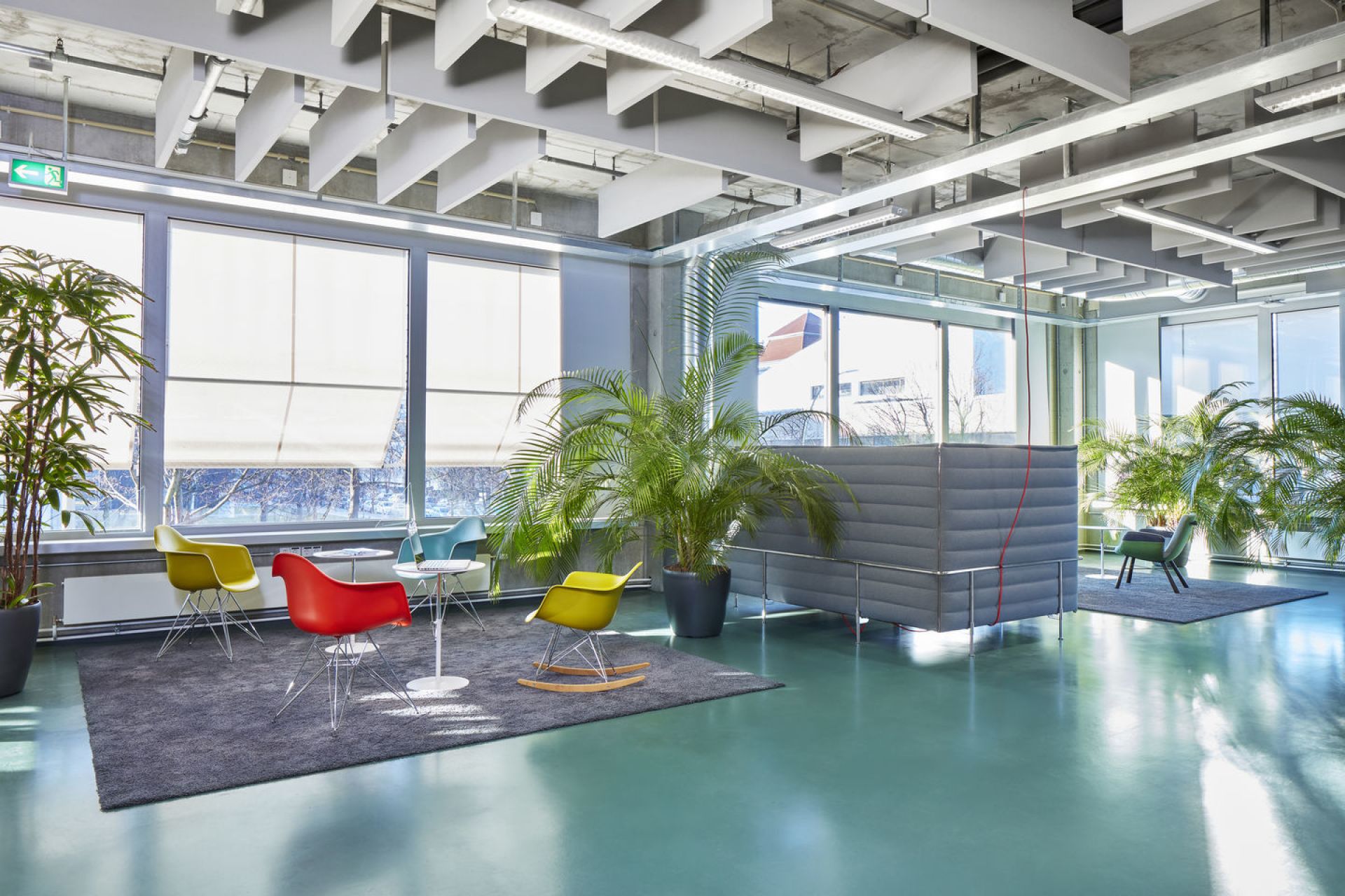 Eames Schaukelstuhl RAR von Vitra in modernem Büroambiente mit Sitzpolster. Designklassiker für Wohnen und Büro.